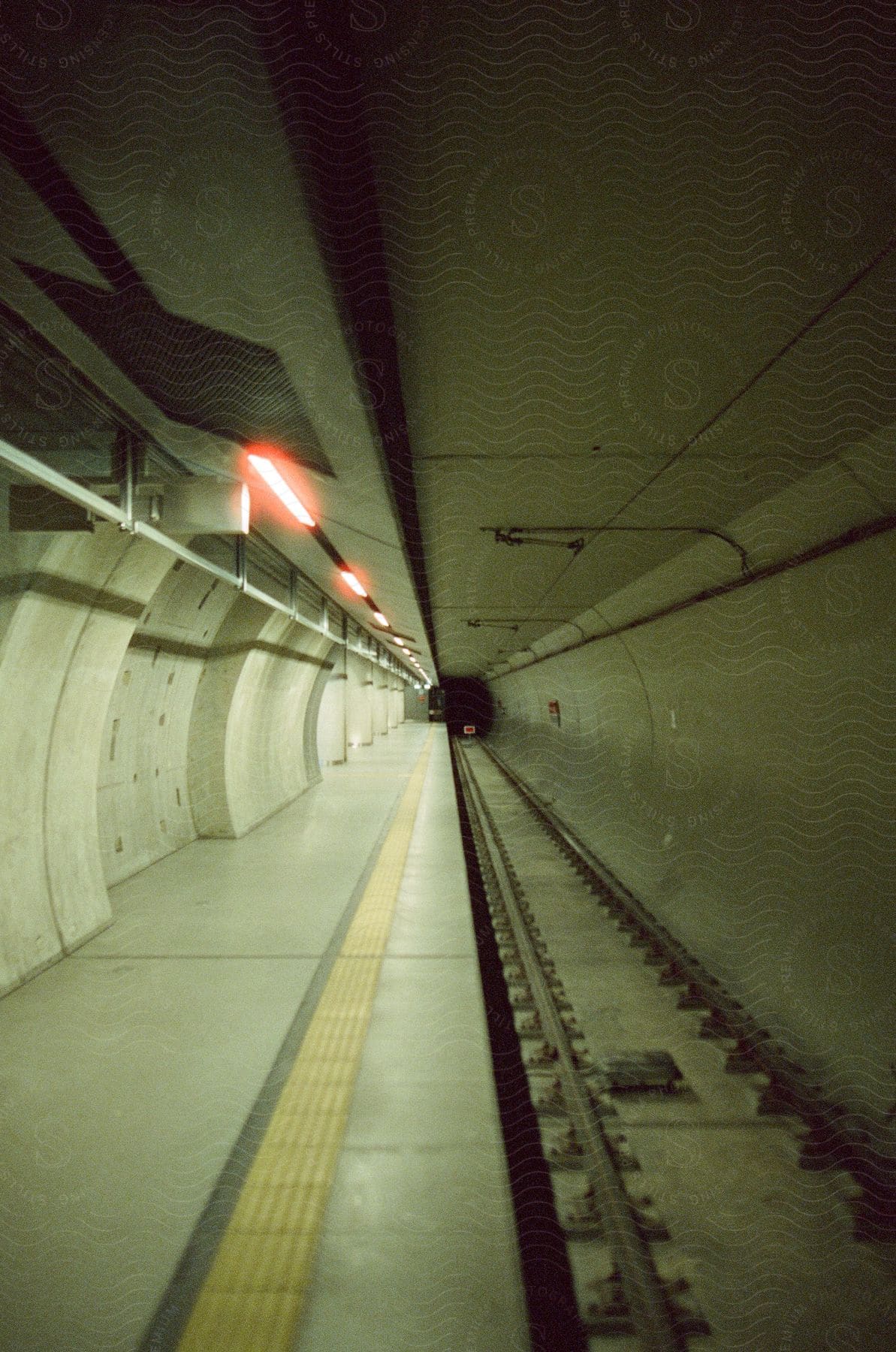 Subway tunnel with railroad in an interior location with low key lighting depicting architecture and transportation