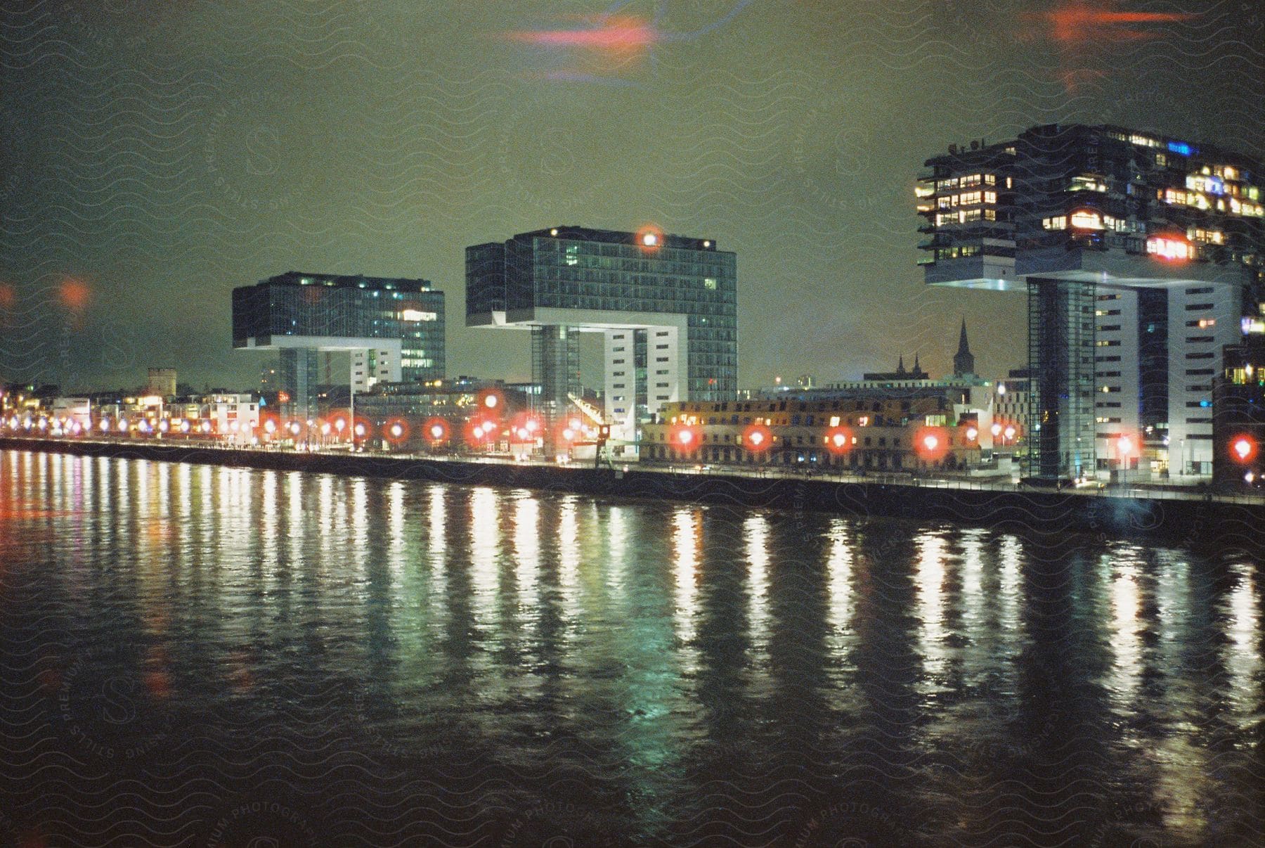 Large buildings line the waterfront in this nighttime cityscape