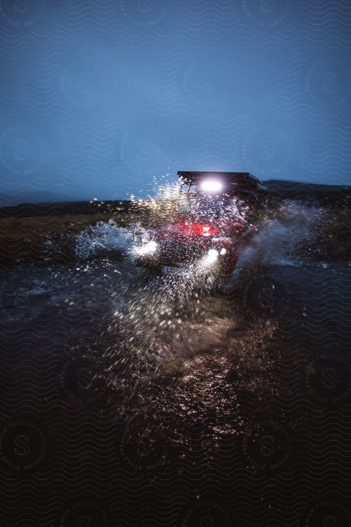 A car parked on a beach at night with the sea in the background