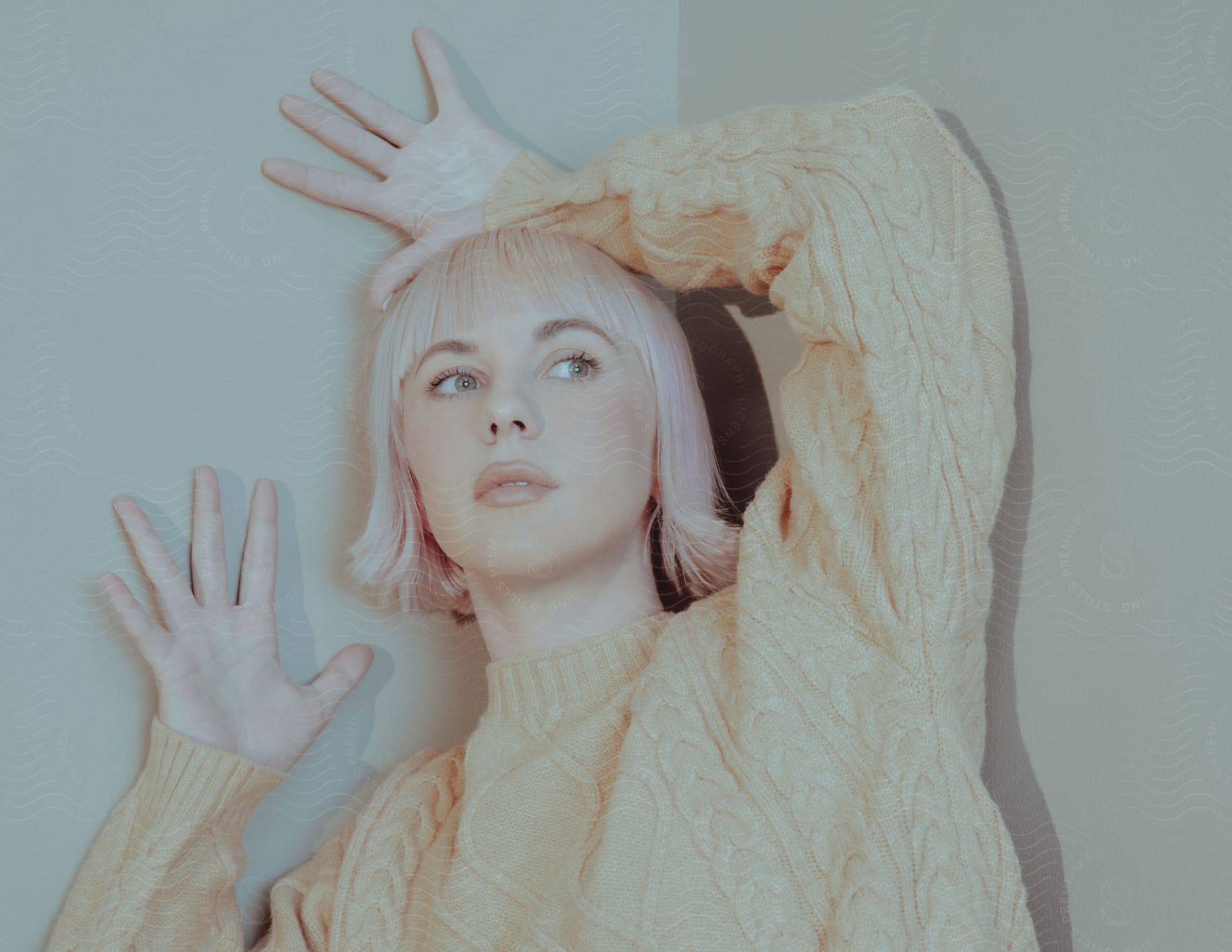 A woman wearing a sweater is posing for a fashion and beauty photograph indoors