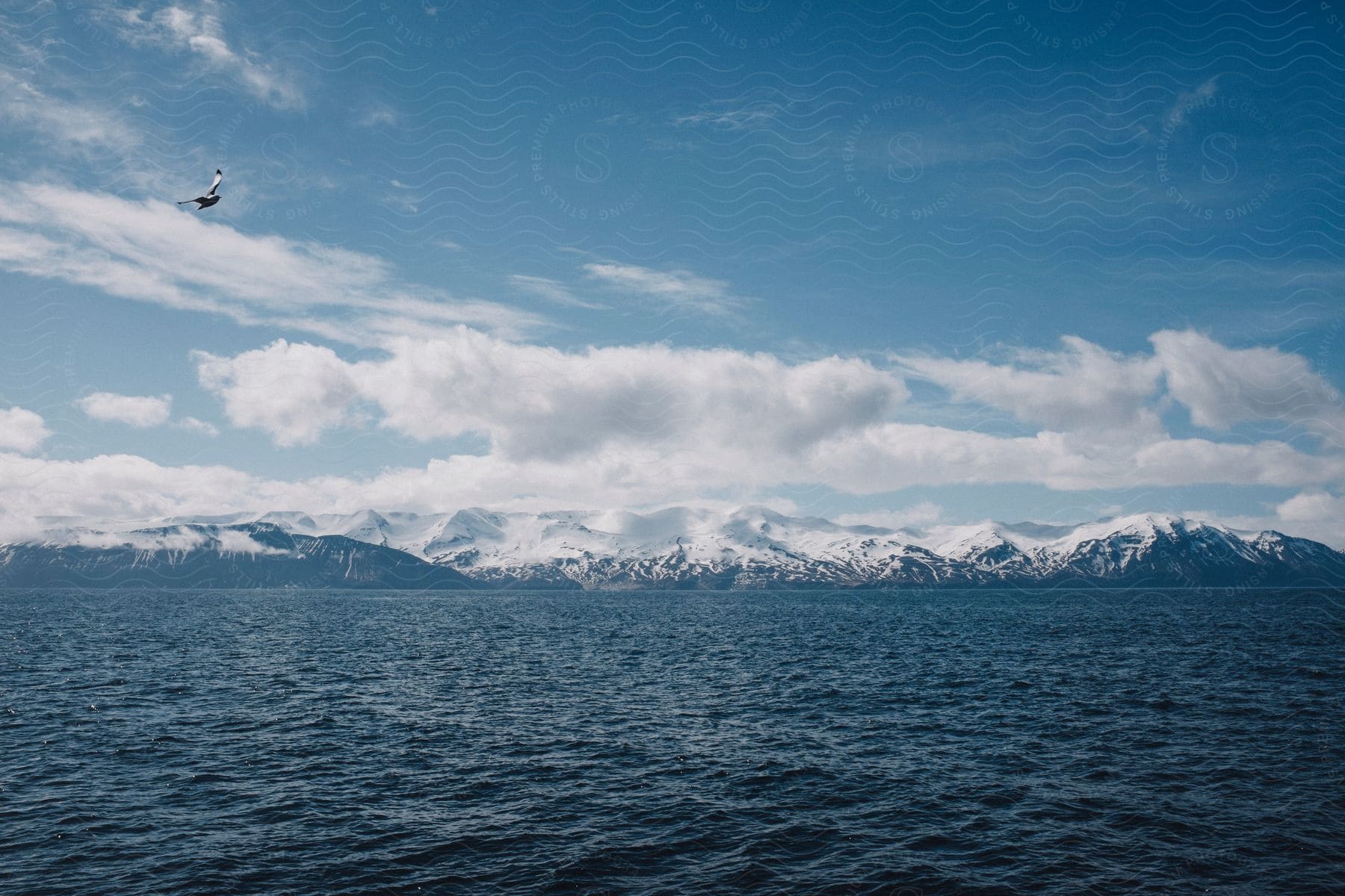 Stock photo of a tranquil lake surrounded by majestic mountains and clear blue skies