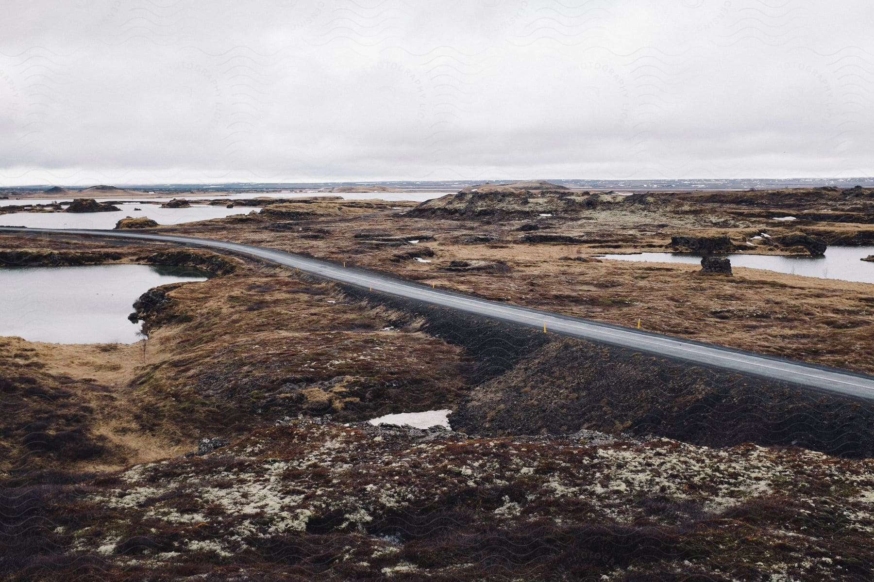 A road winds through a wild landscape with a lake