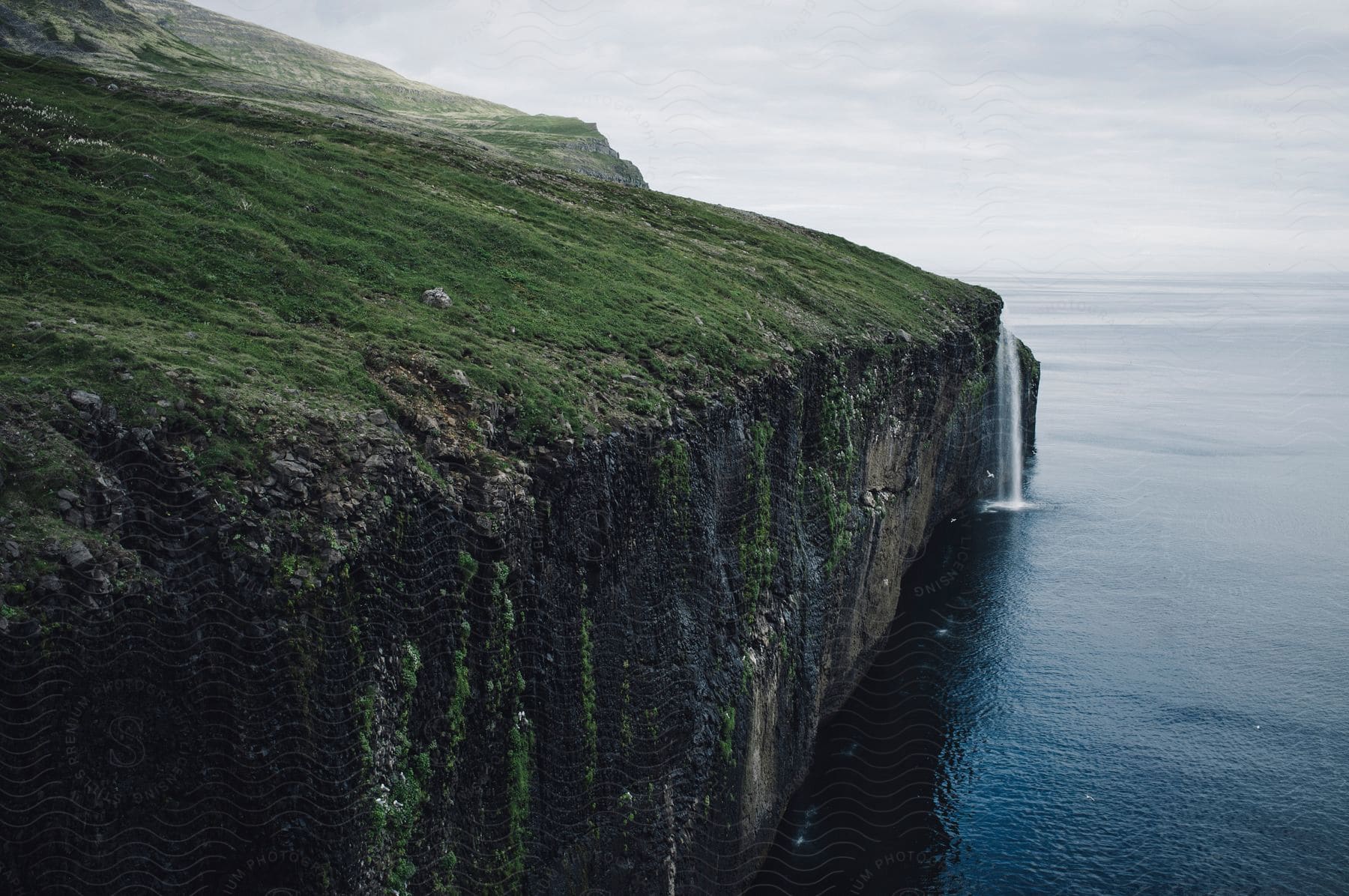 A tranquil coastal landscape with water sky clouds and cliffs