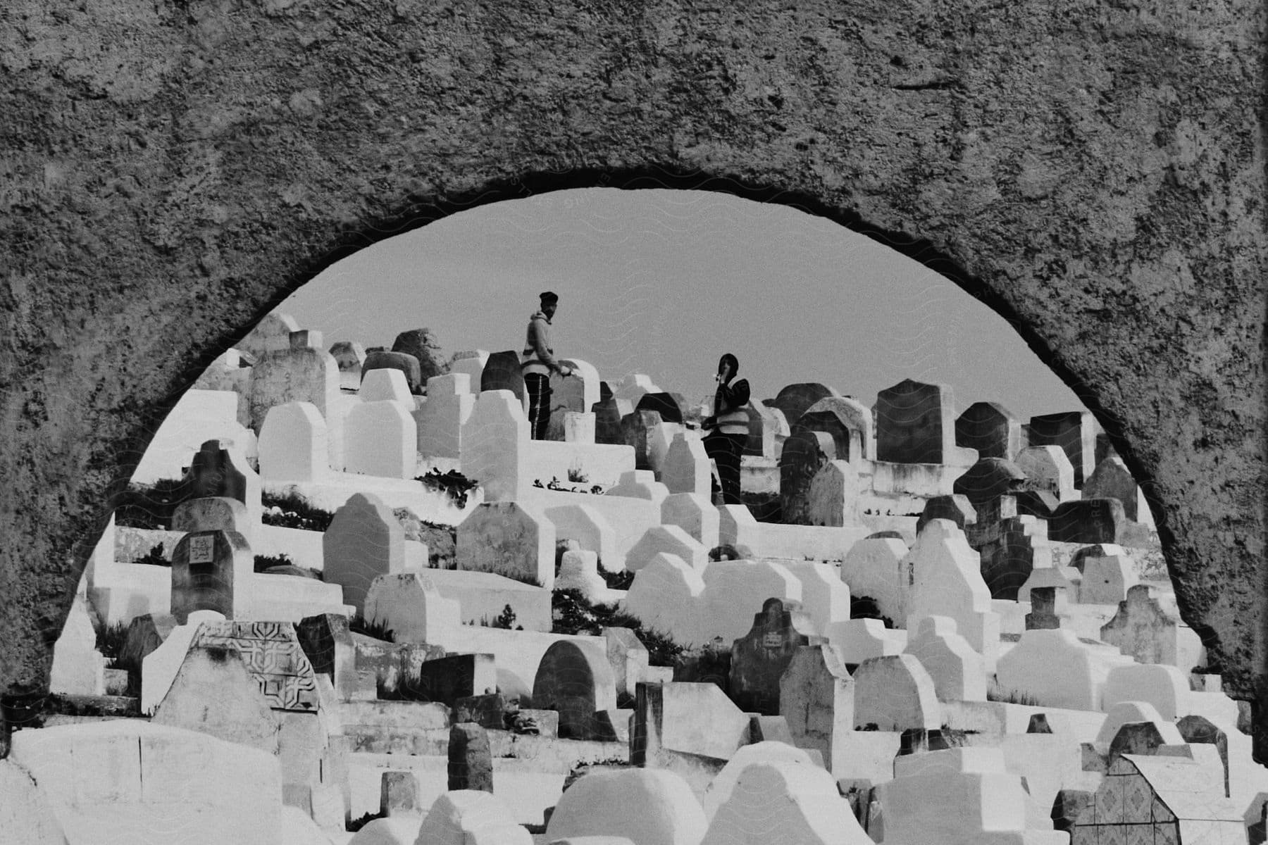 Two people standing at the graveyard intently look at the camera