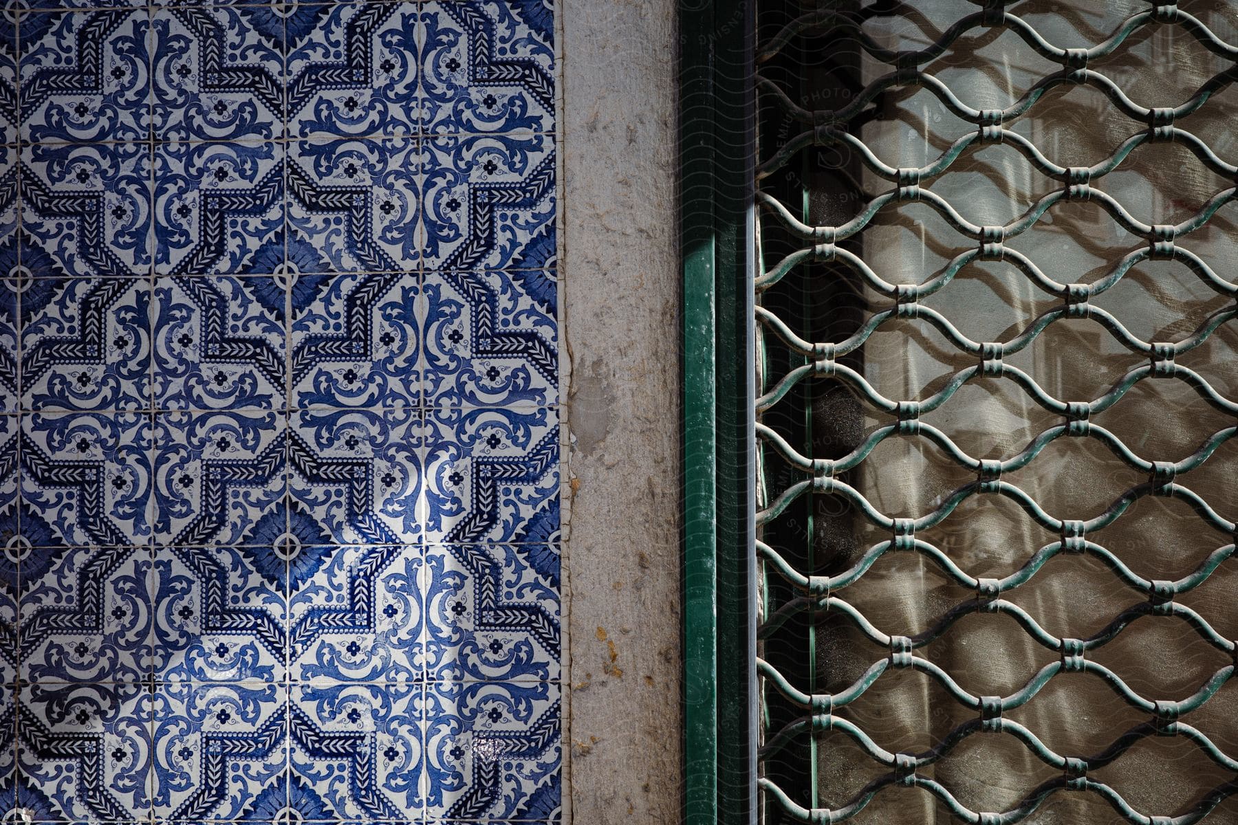 A detailed view of a structure with painted tiles and a metal grid next to it