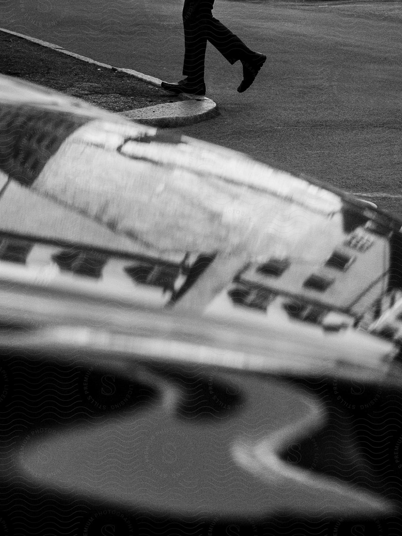 A black and white object up close with a persons feet walking in the distance