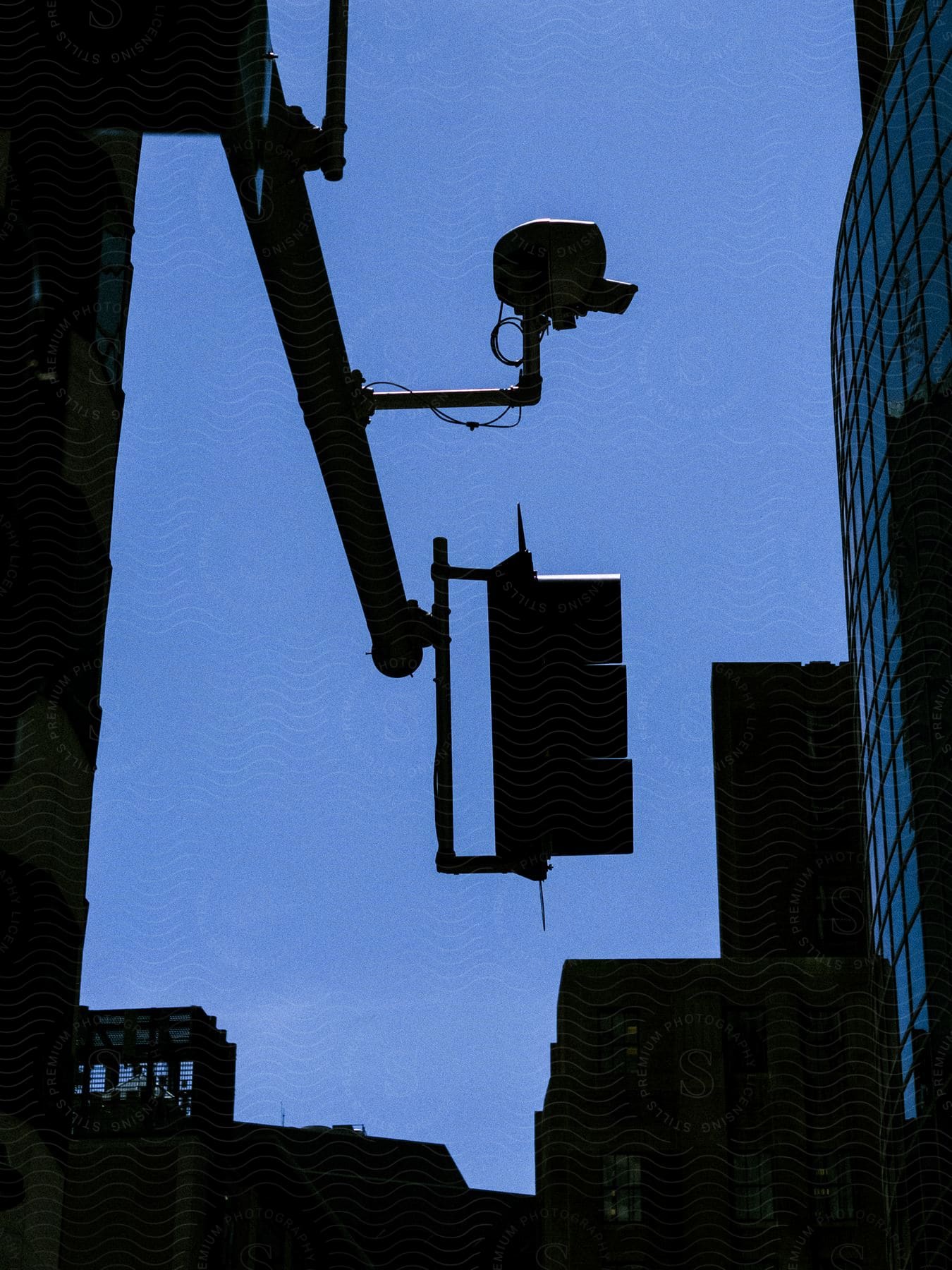 Silhouetted traffic lights against a blue sky