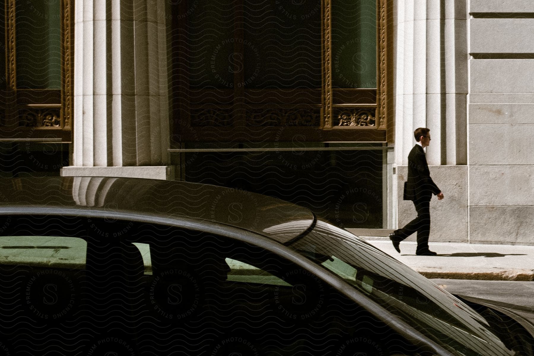 Man in black suit walks down the street in downtown boston