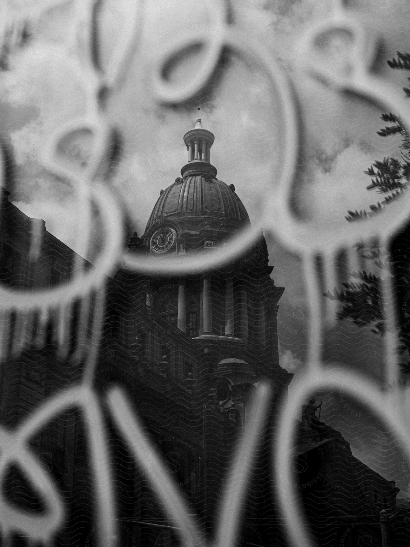 Classical building dome visible through gate in blackandwhite