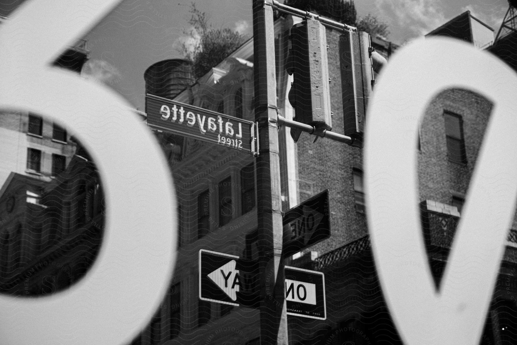 A black and white photo of street signs in front of a city building