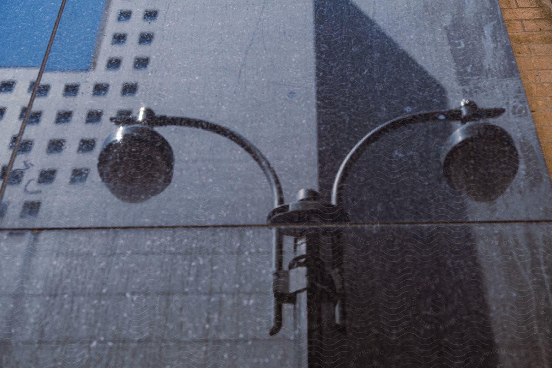 A lamp pole in front of a building reflected in a window