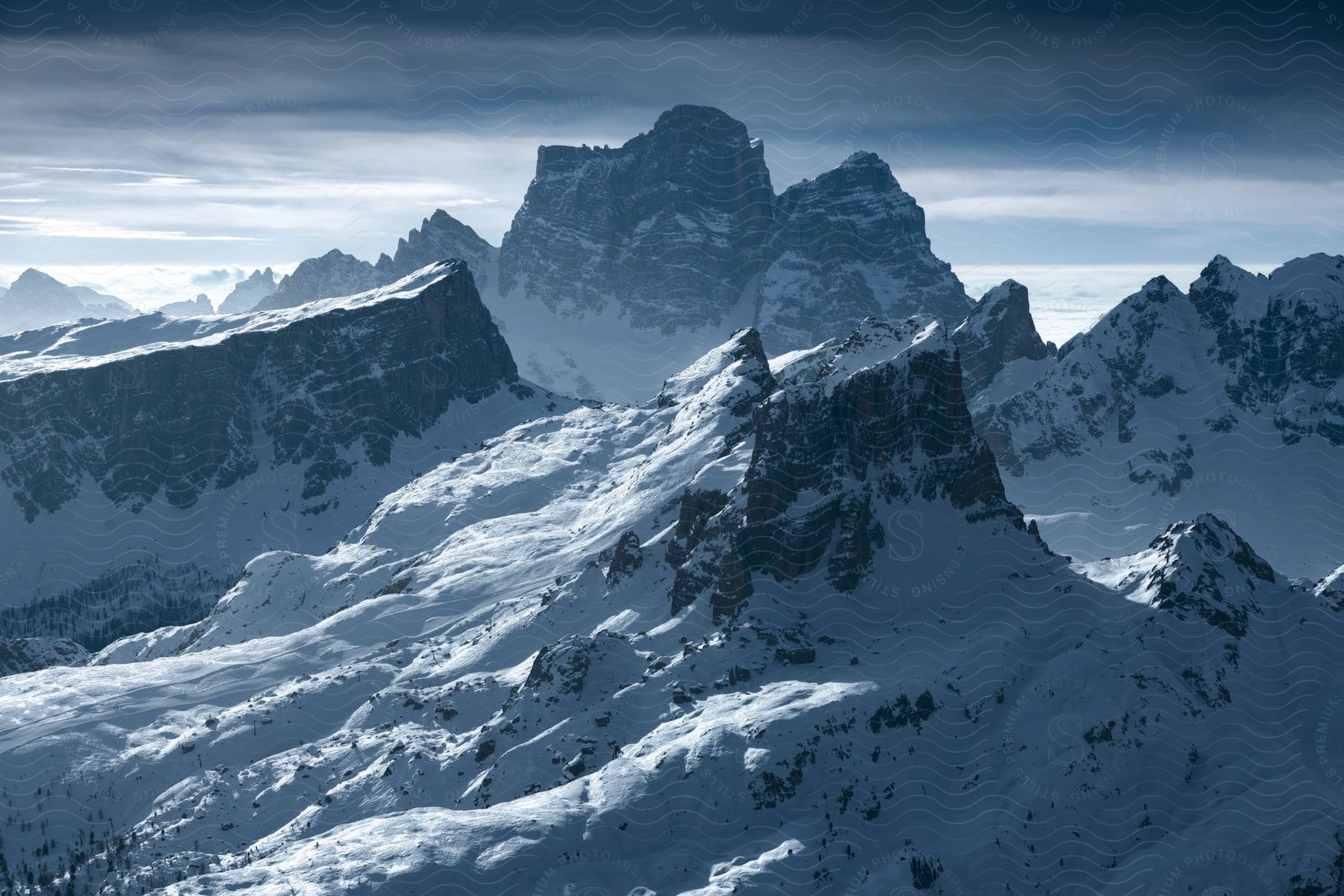 Snowcovered rocky mountains with cloudy sky in the dolomites