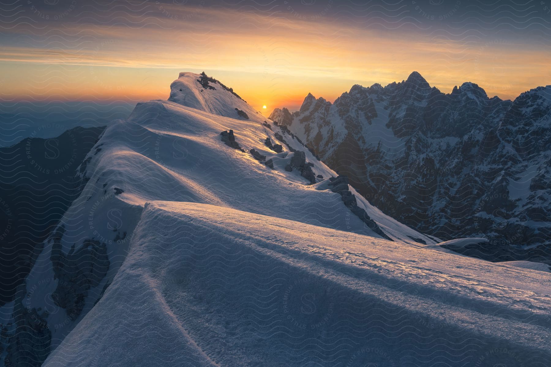 Snowcovered mountain tops with a sunset