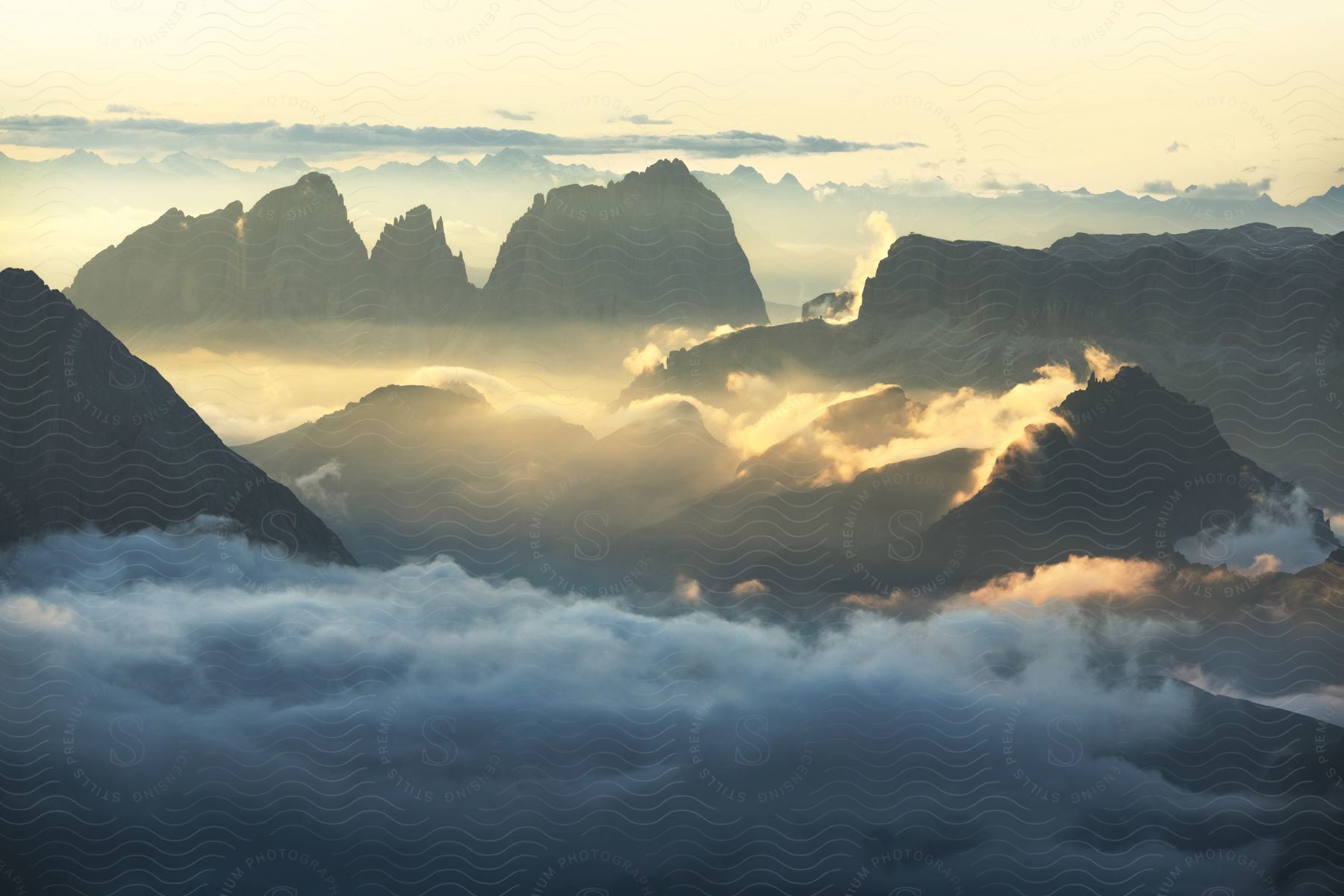 Dawn breaking over high peaks touching the clouds in the dolomites