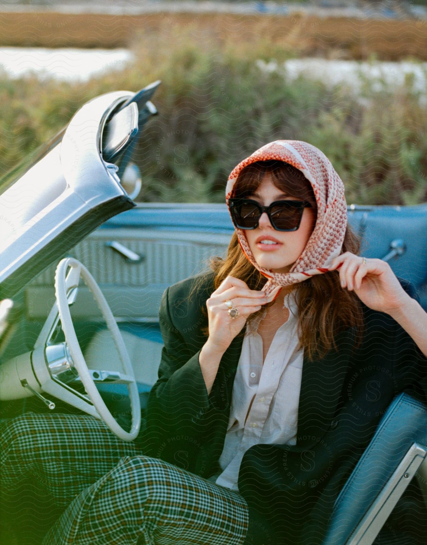 Stock photo of elegant dressed woman sitting in a blue car