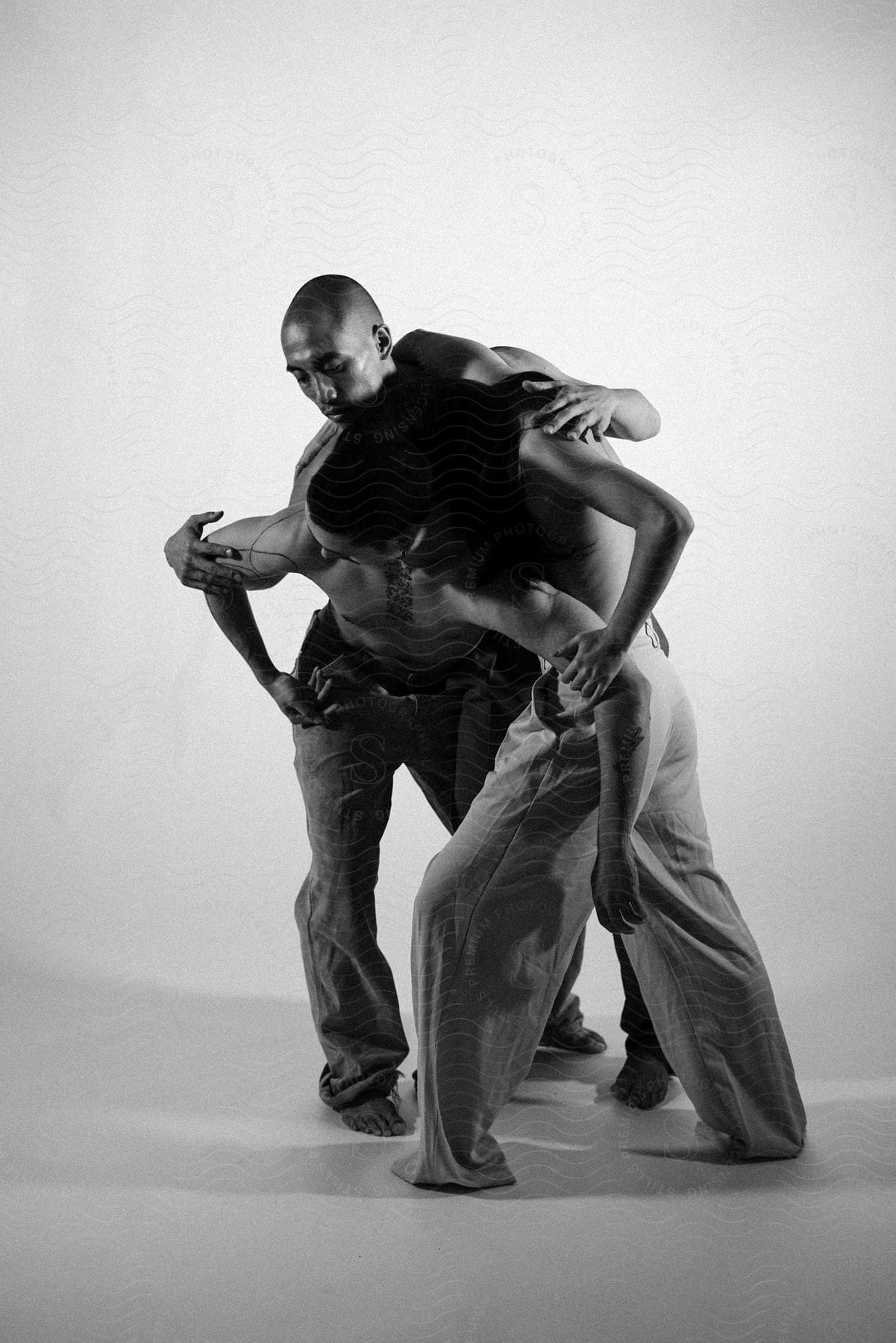 Stock photo of three people including an adult male dancing in a white studio space