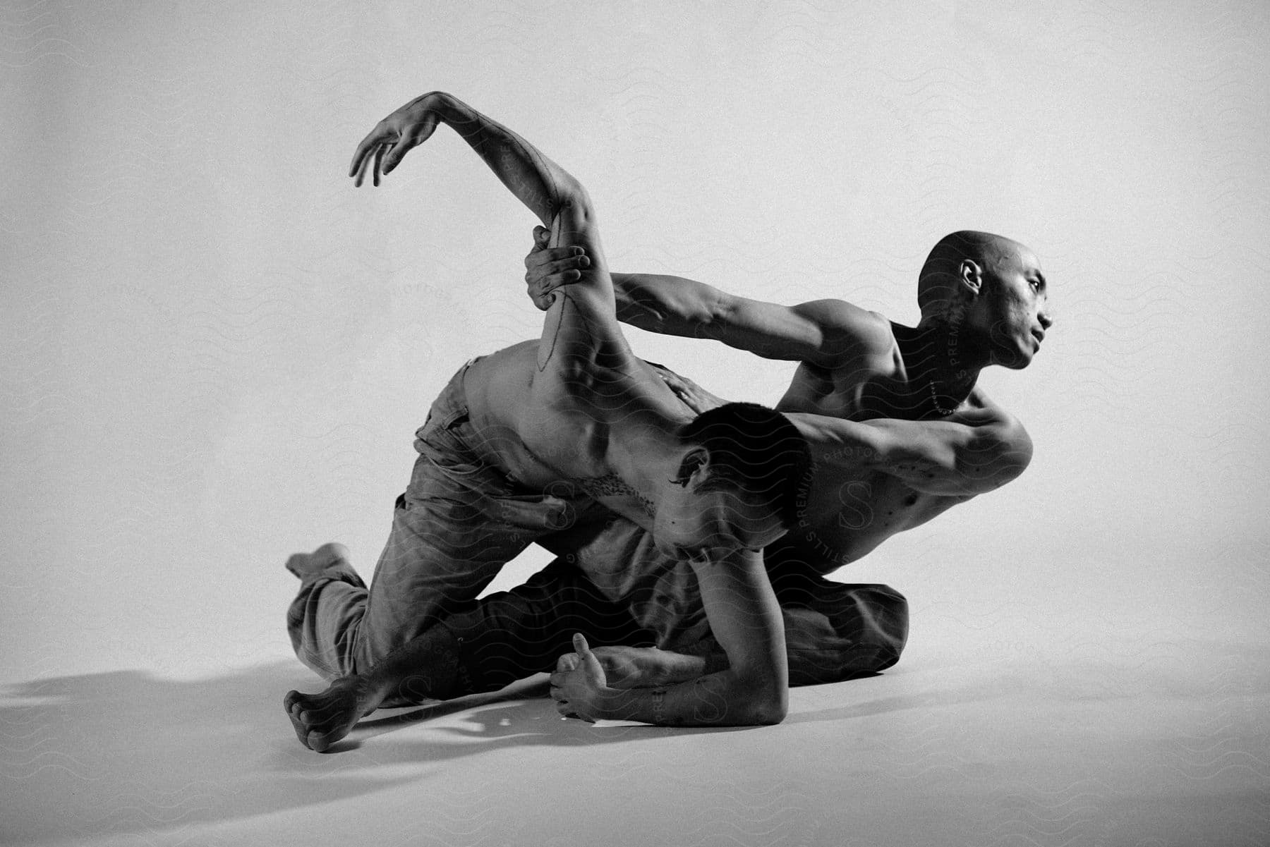 Two people a man and a woman are dancing in a white studio space