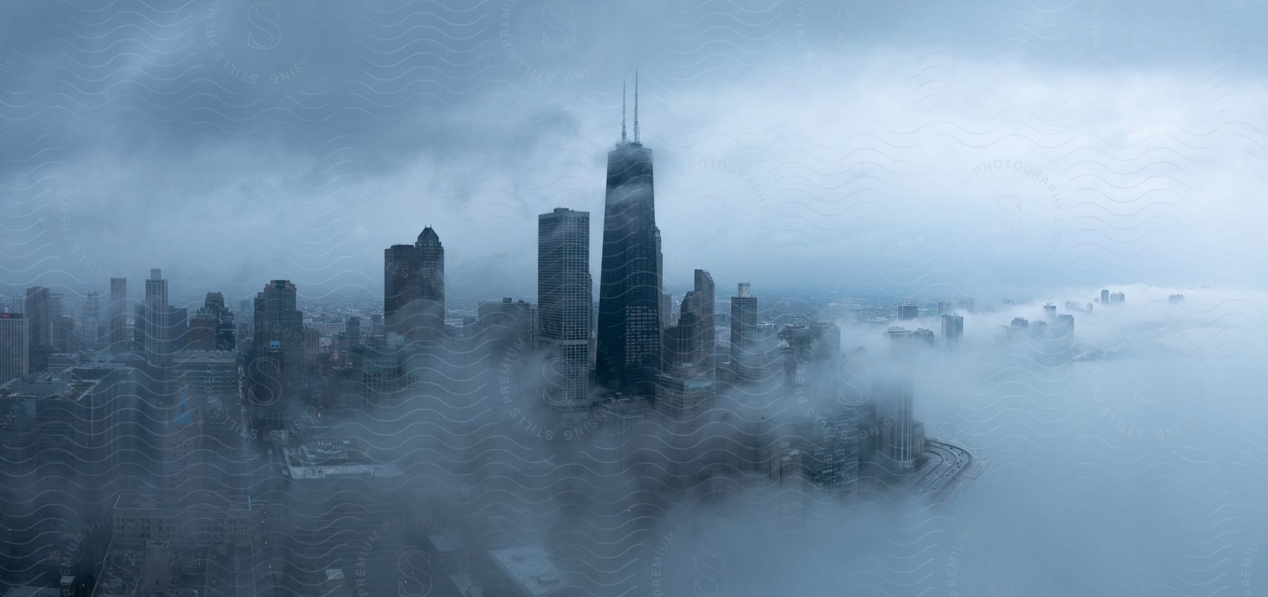 A Foggy Cityscape With Skyscrapers And A Cloudy Sky Reflected In Water