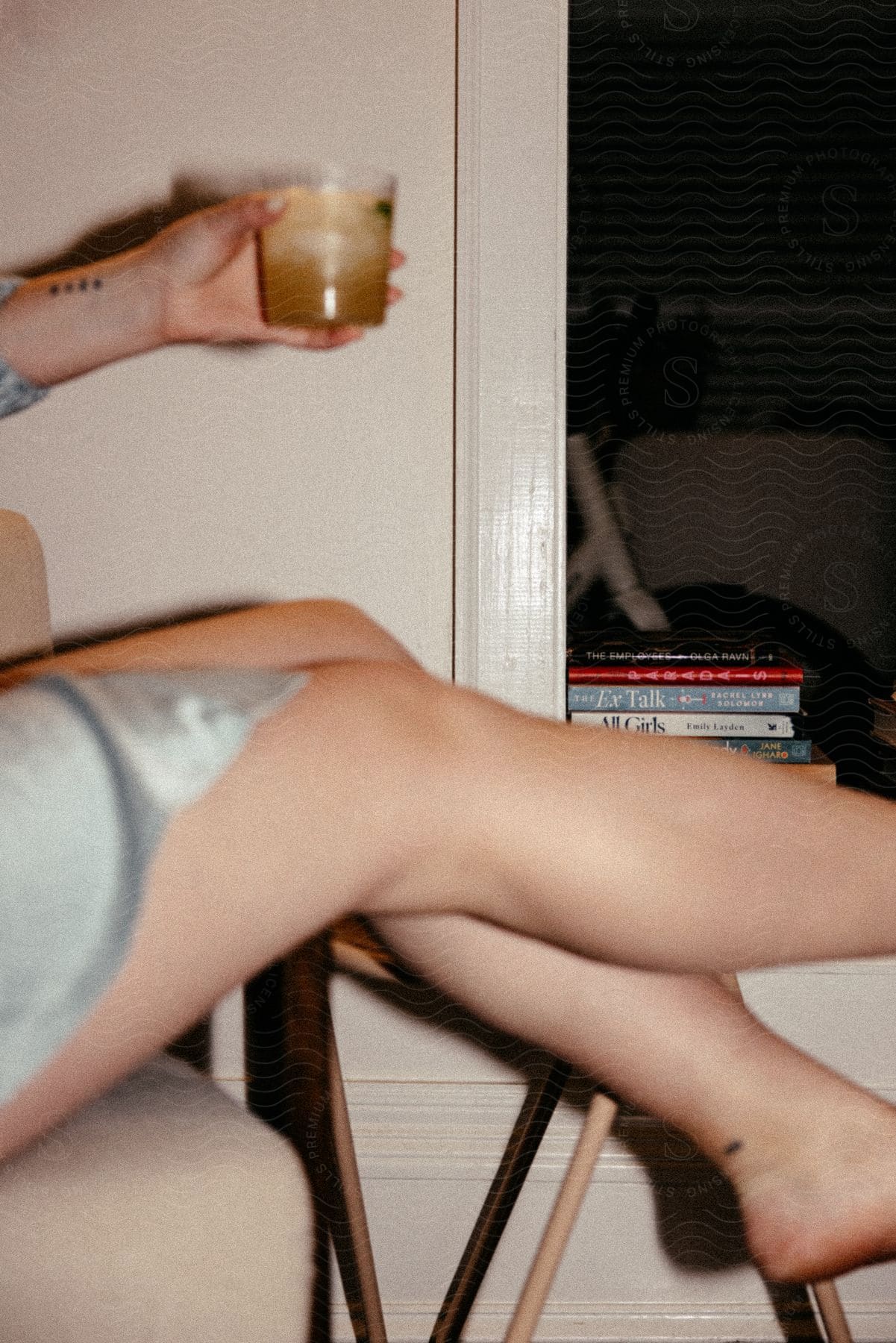 Close up of a womans legs holding a drink at a party indoors