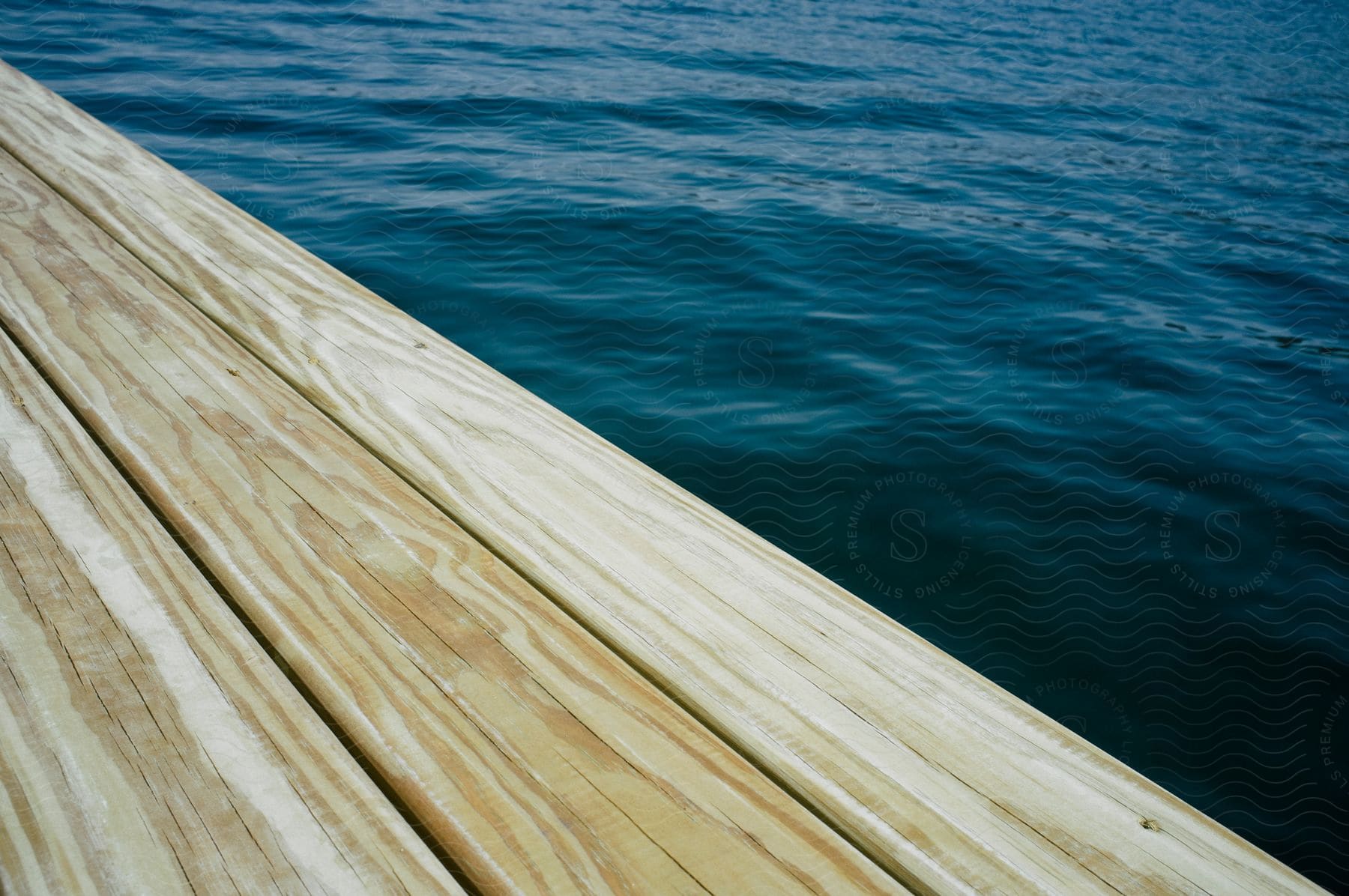 A wooden dock extends over the ocean along the shoreline