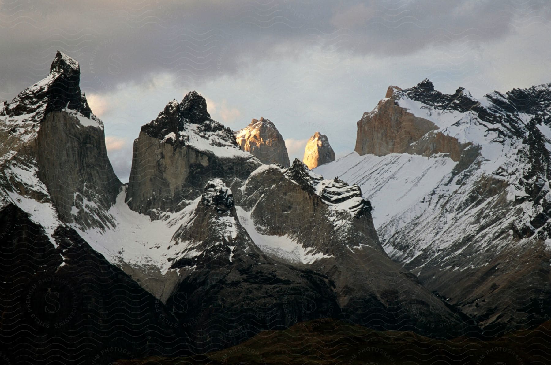 Snow covers slopes on a mountain range with deep ravines