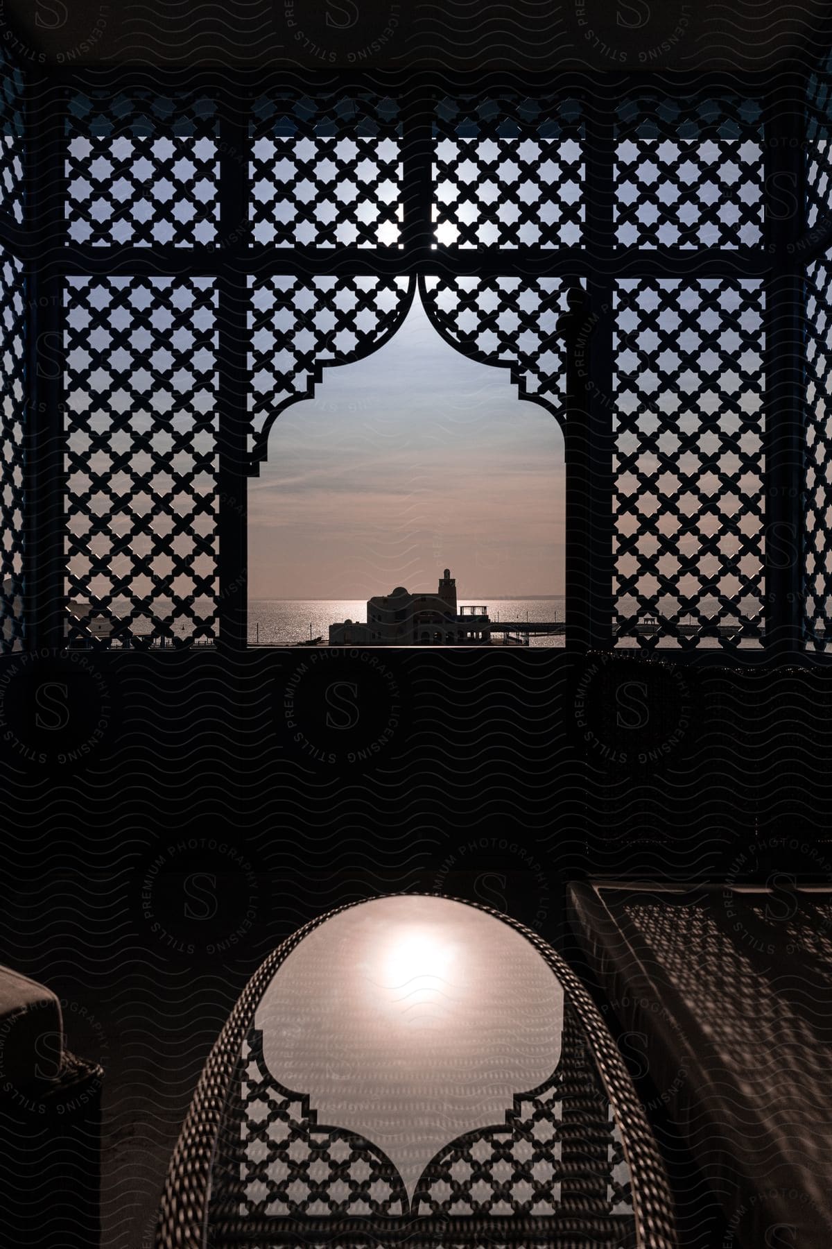 A glass table reflects the ornate latticework of a building in qatar