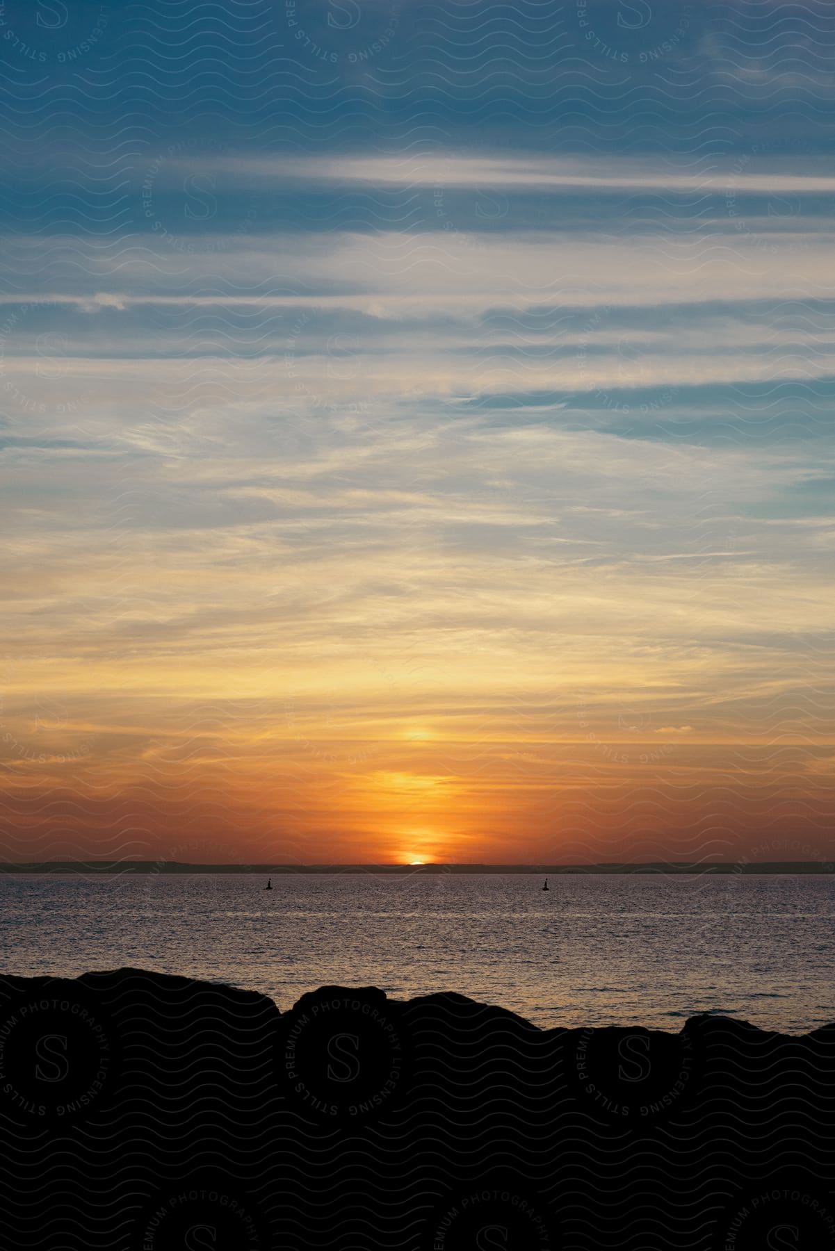 Silhouetted land against a sunset near the sea