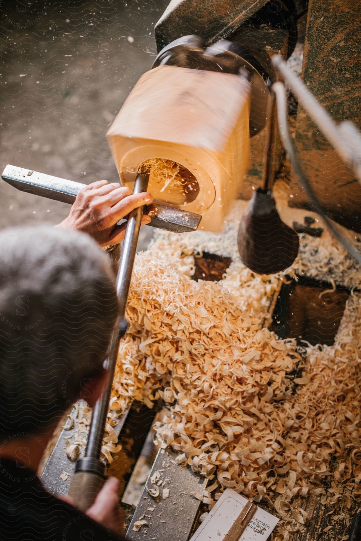 A woodworker hollows out the middle of a wood block on his lathe