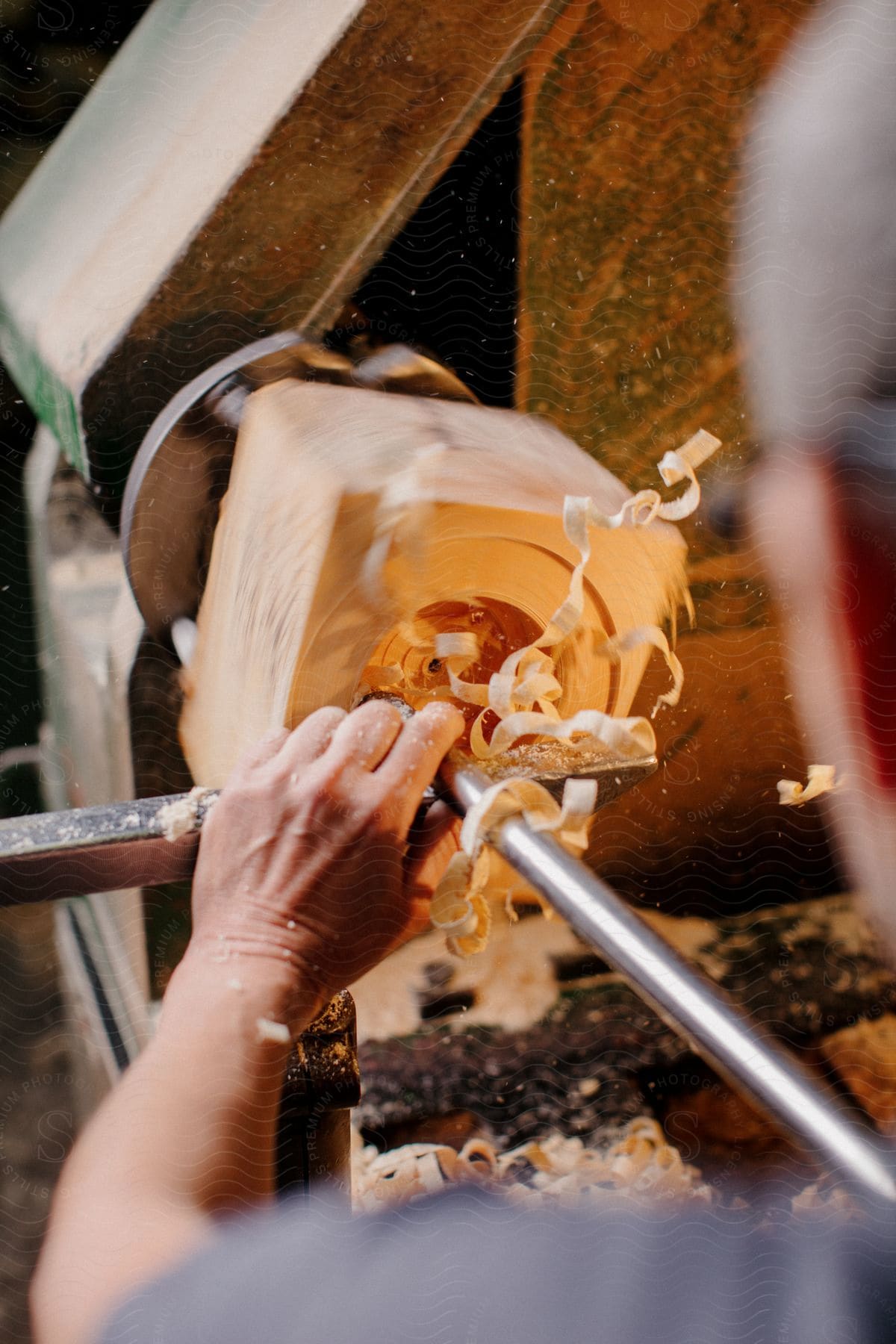 Man turning a block of wood on a lathe