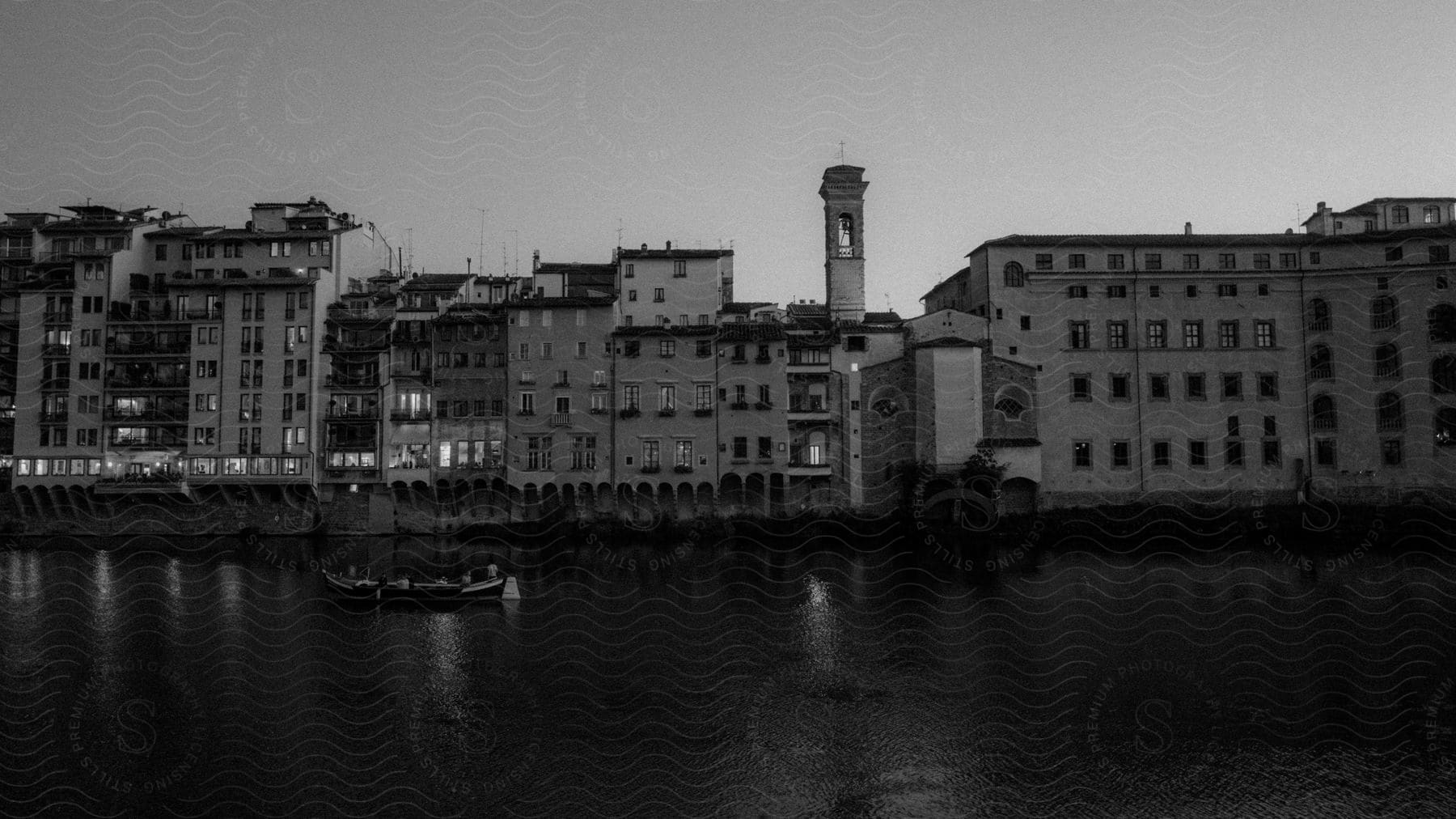 Small boat with people inside crossing through the shoreline next to the city