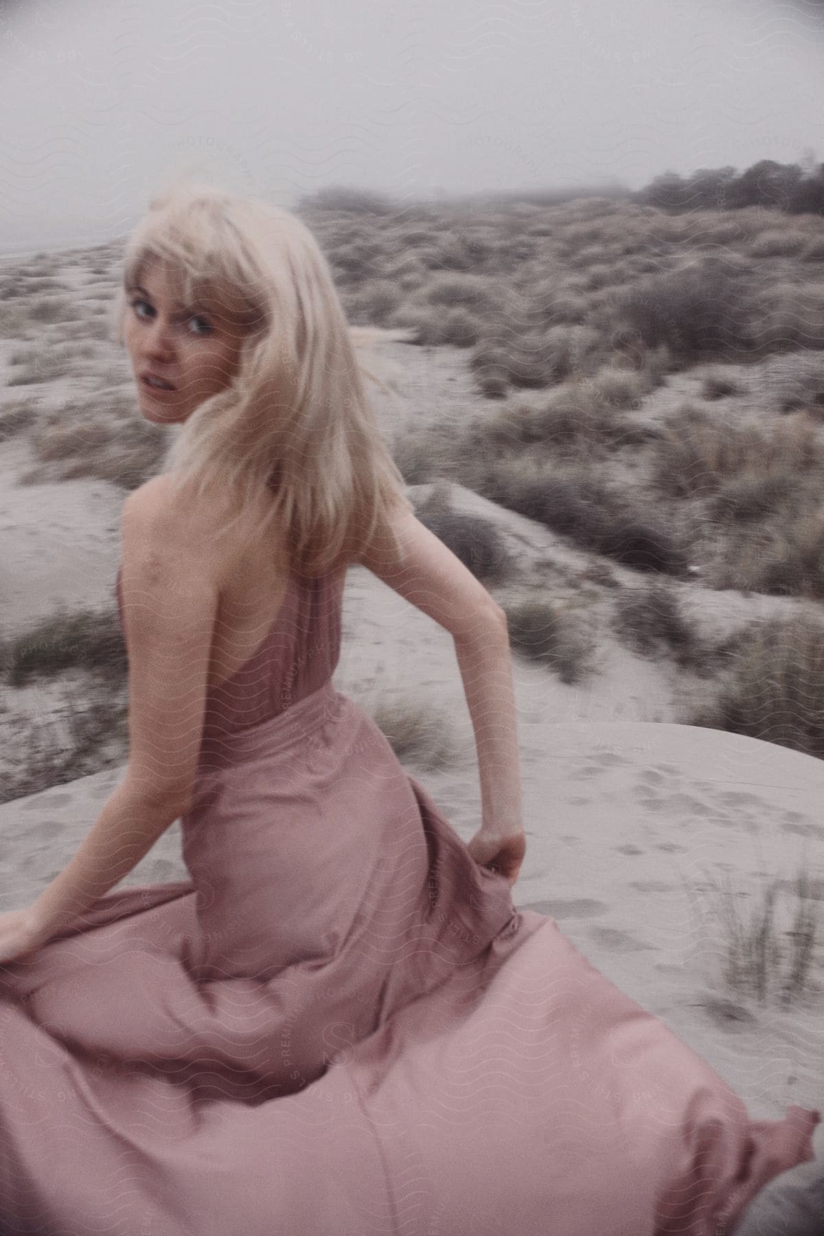 Young woman posing for a photograph in an outdoor plain with low vegetation