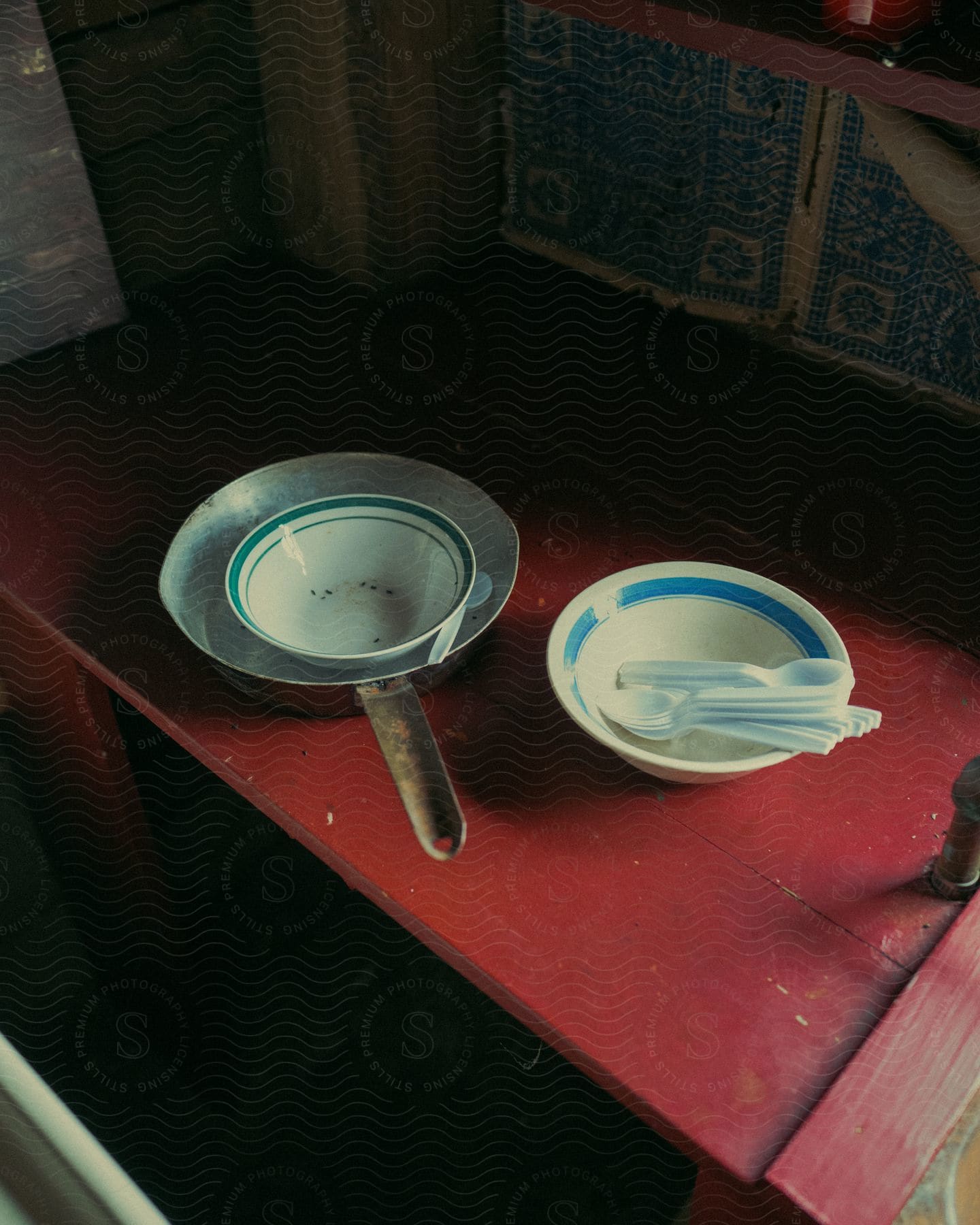 A wooden table with dishes and cookware