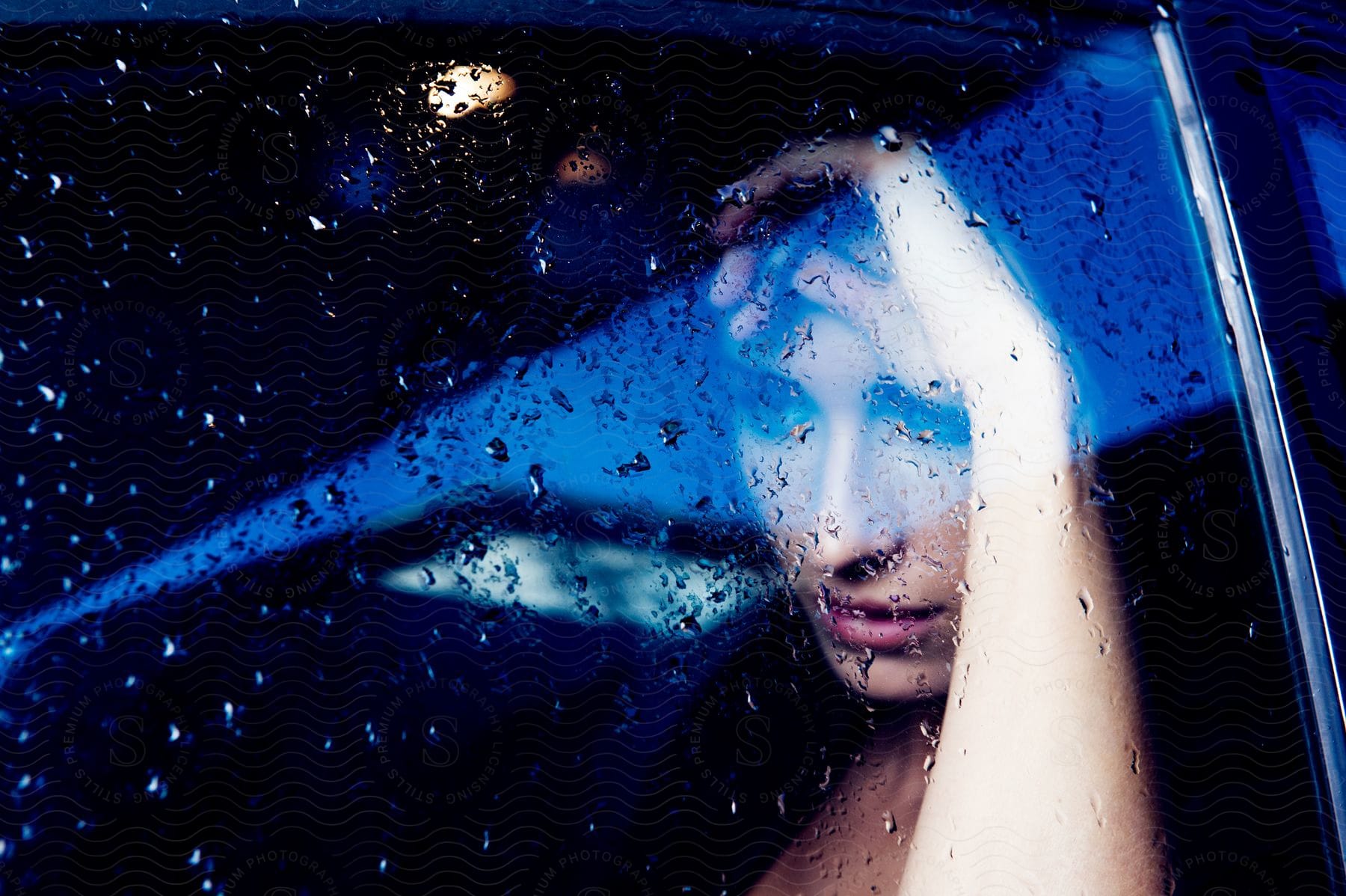 A woman sitting in her car at night