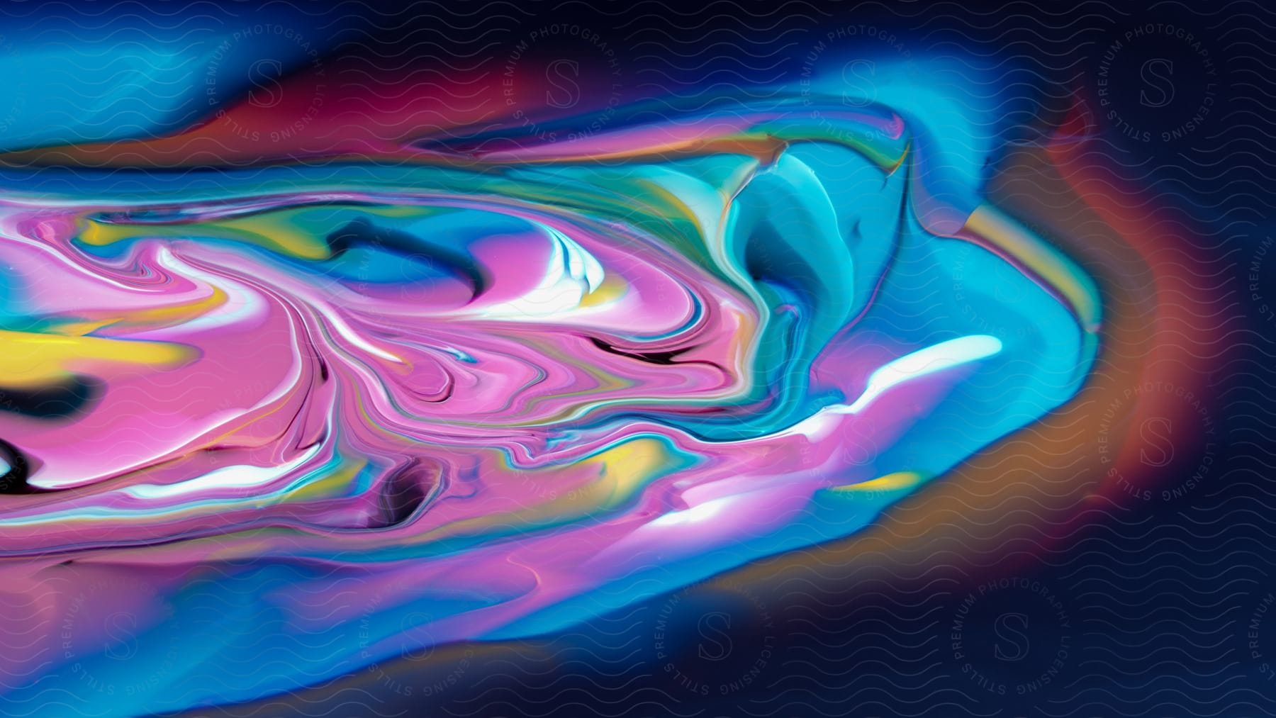Swirls of pink blue and yellow colored liquid in an abstract multicolored fluid art image with neon color and highlight glow