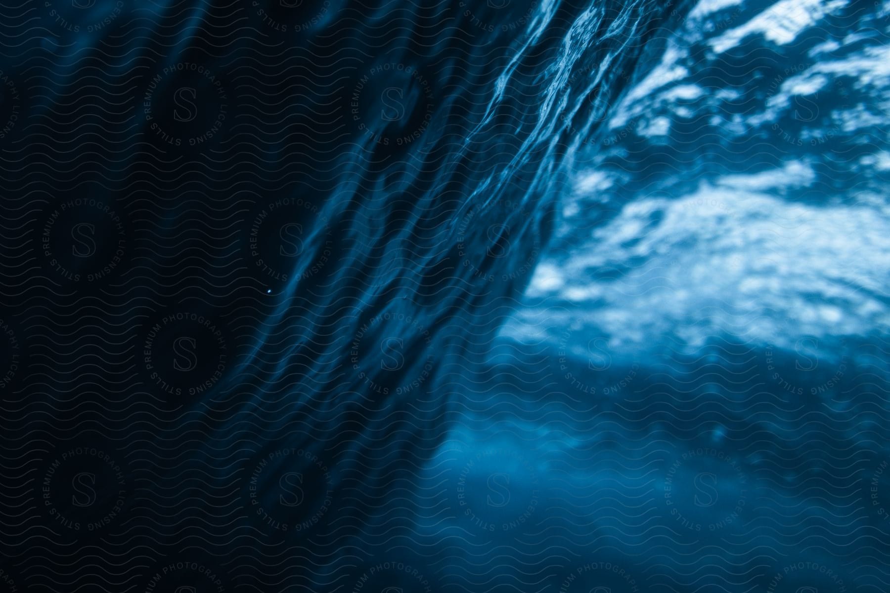 Underwater view of an ocean wave turning.