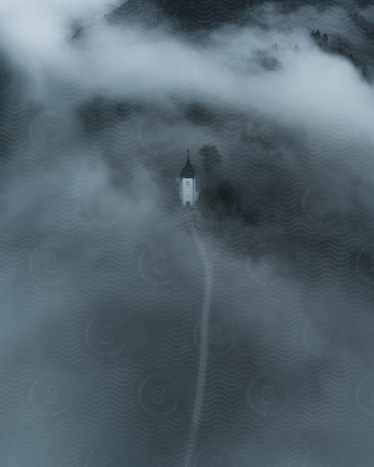 A house surrounded by clouds near mountains