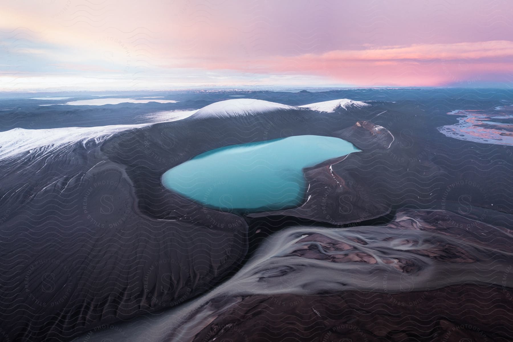 A beautiful aerial shot of a lake with the sunset in the background.