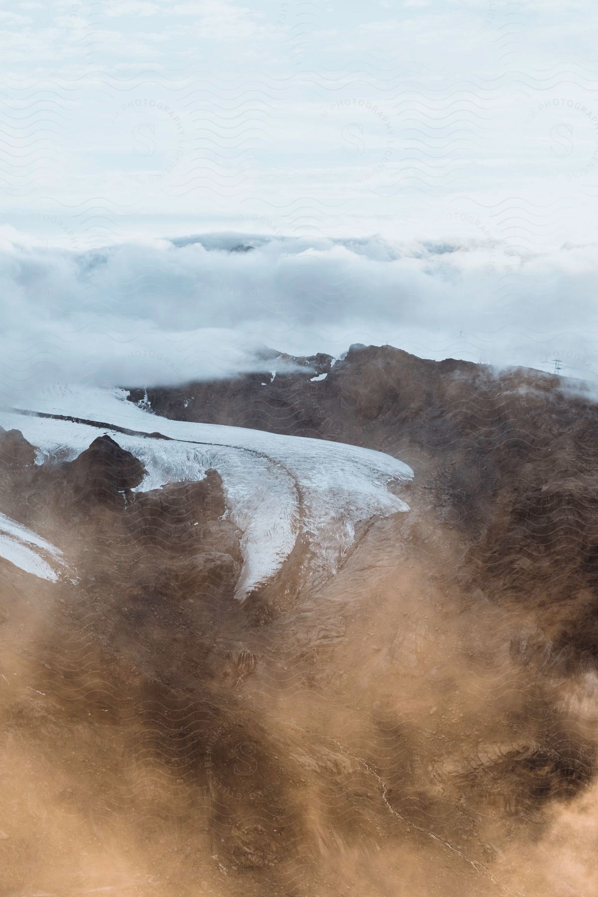 A serene landscape of a mountain range with an ice cap and fog