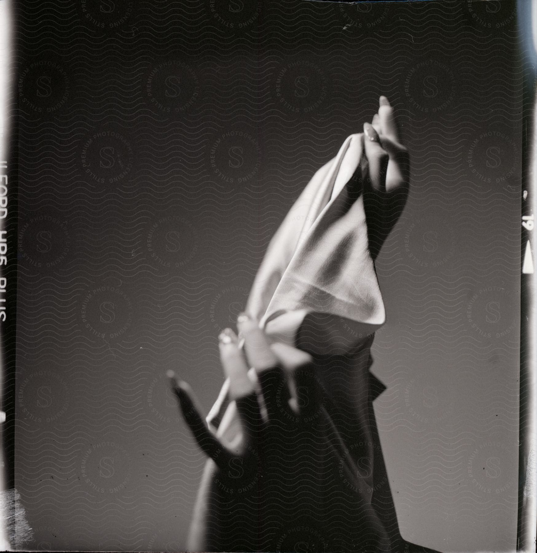 Female hands holding a white cloth in black and white