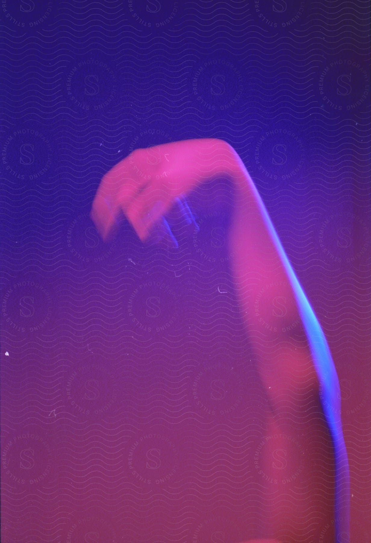 An arm moving in blue and purple light
