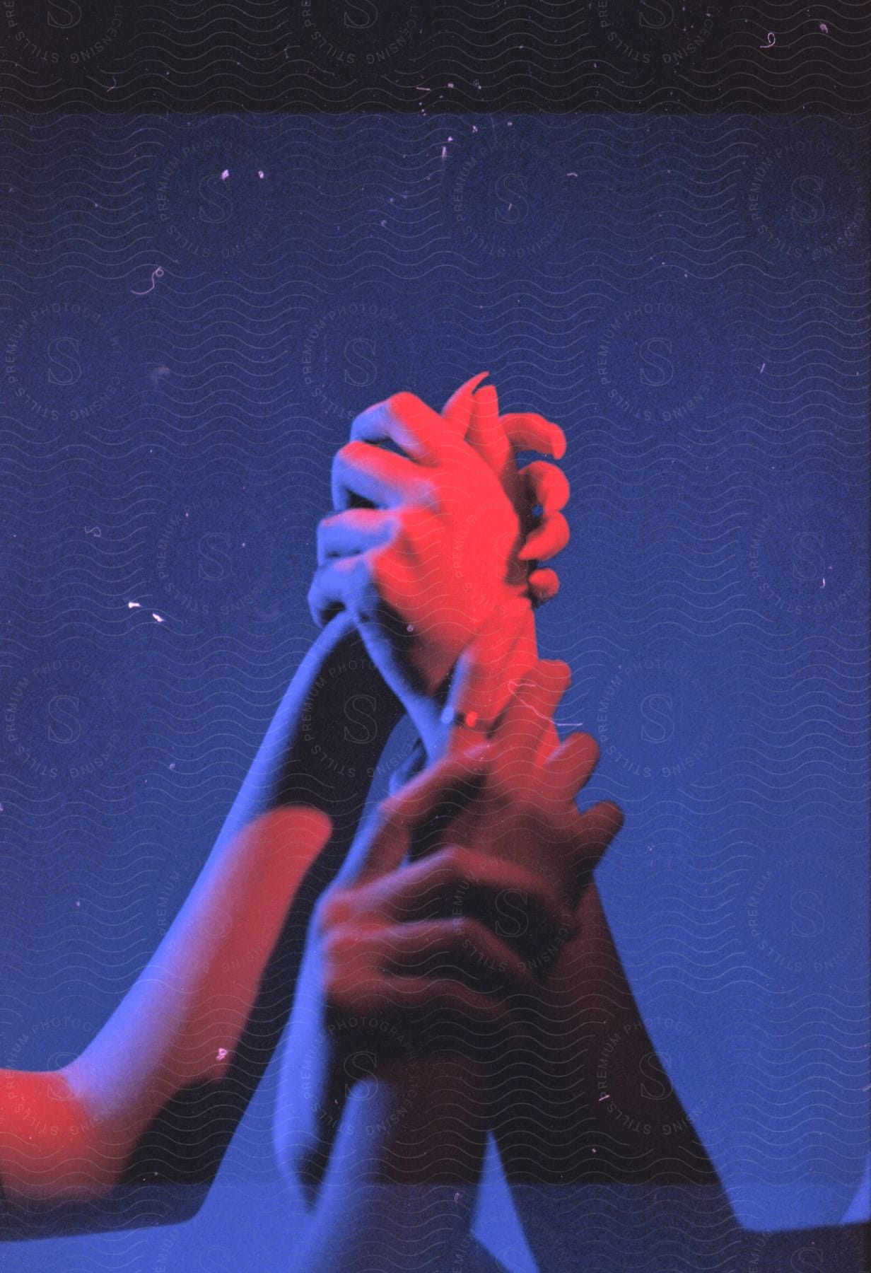 Two peoples hands in the night one wearing a glove performing a gesture