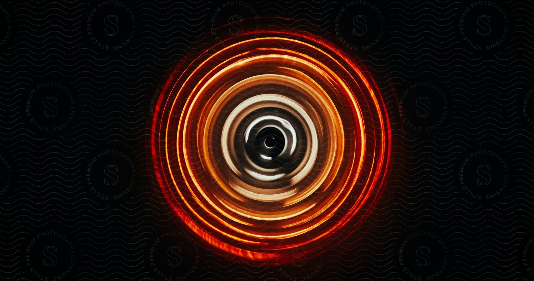 Red, orange and gray concentric circles in the dark.