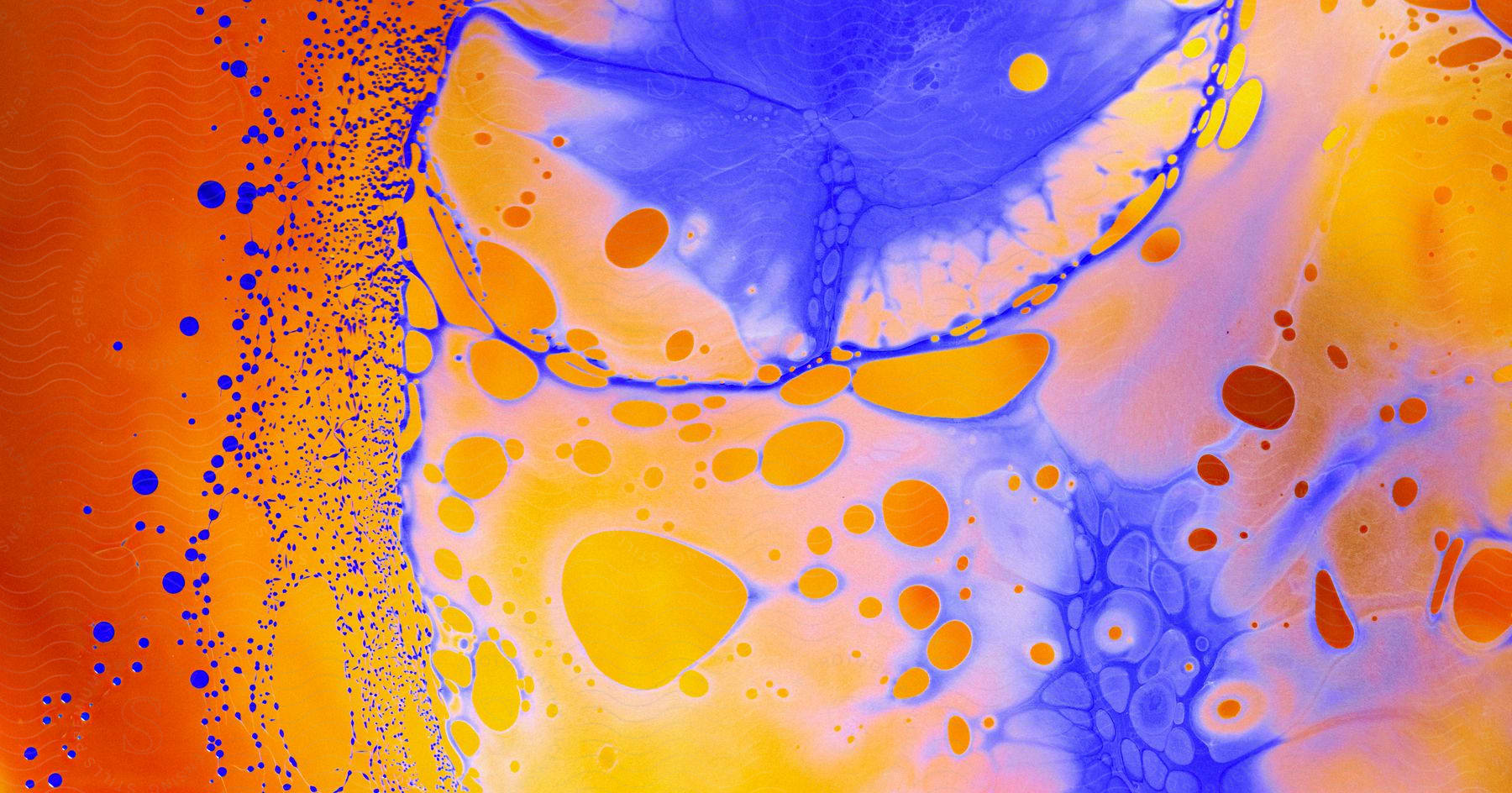 Abstract painting of orange, yellow, and blue liquid, with orange and blue spots on an orange background.