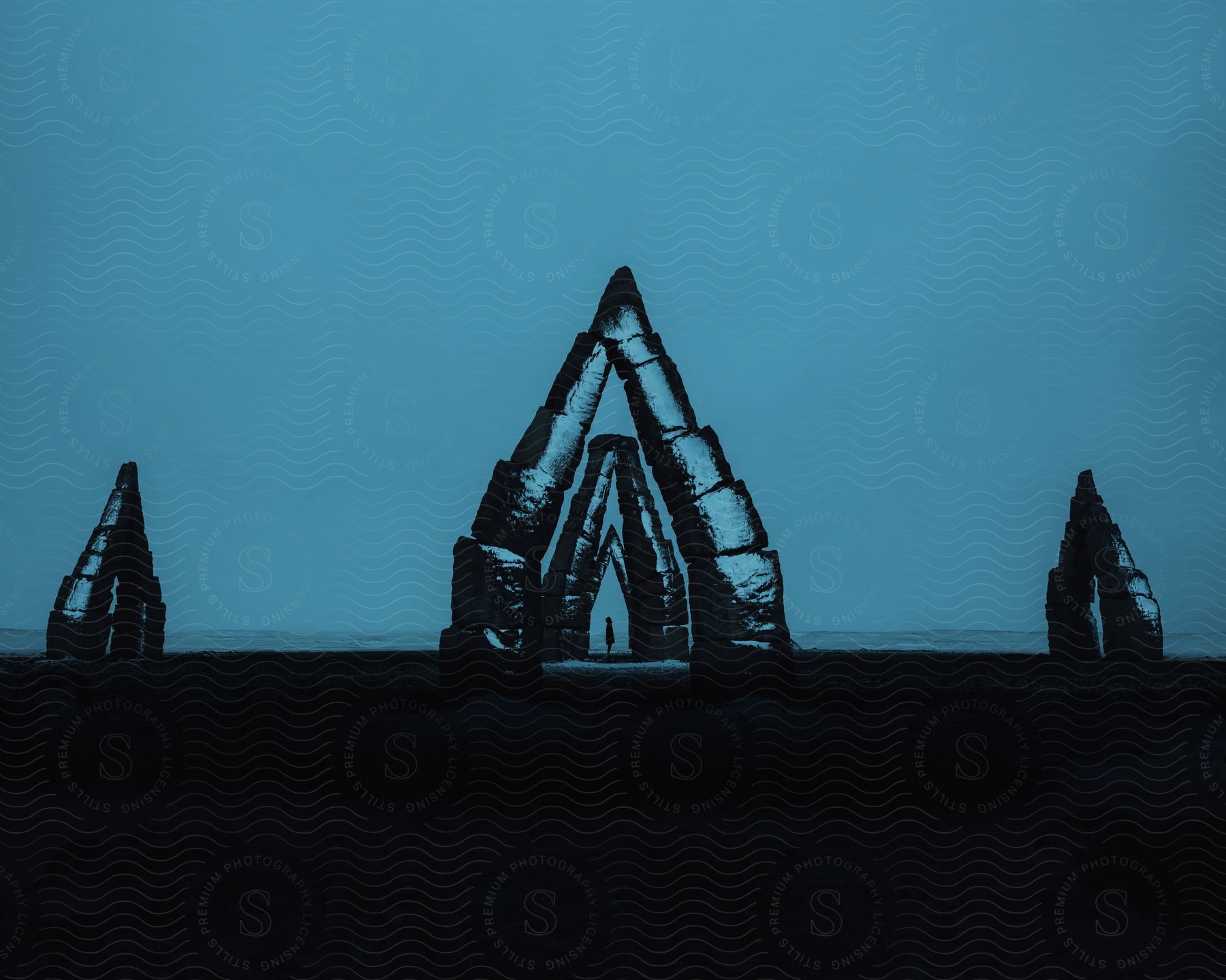 Blue reflects on colossal arctic henge stone monolith sculpture in iceland at night