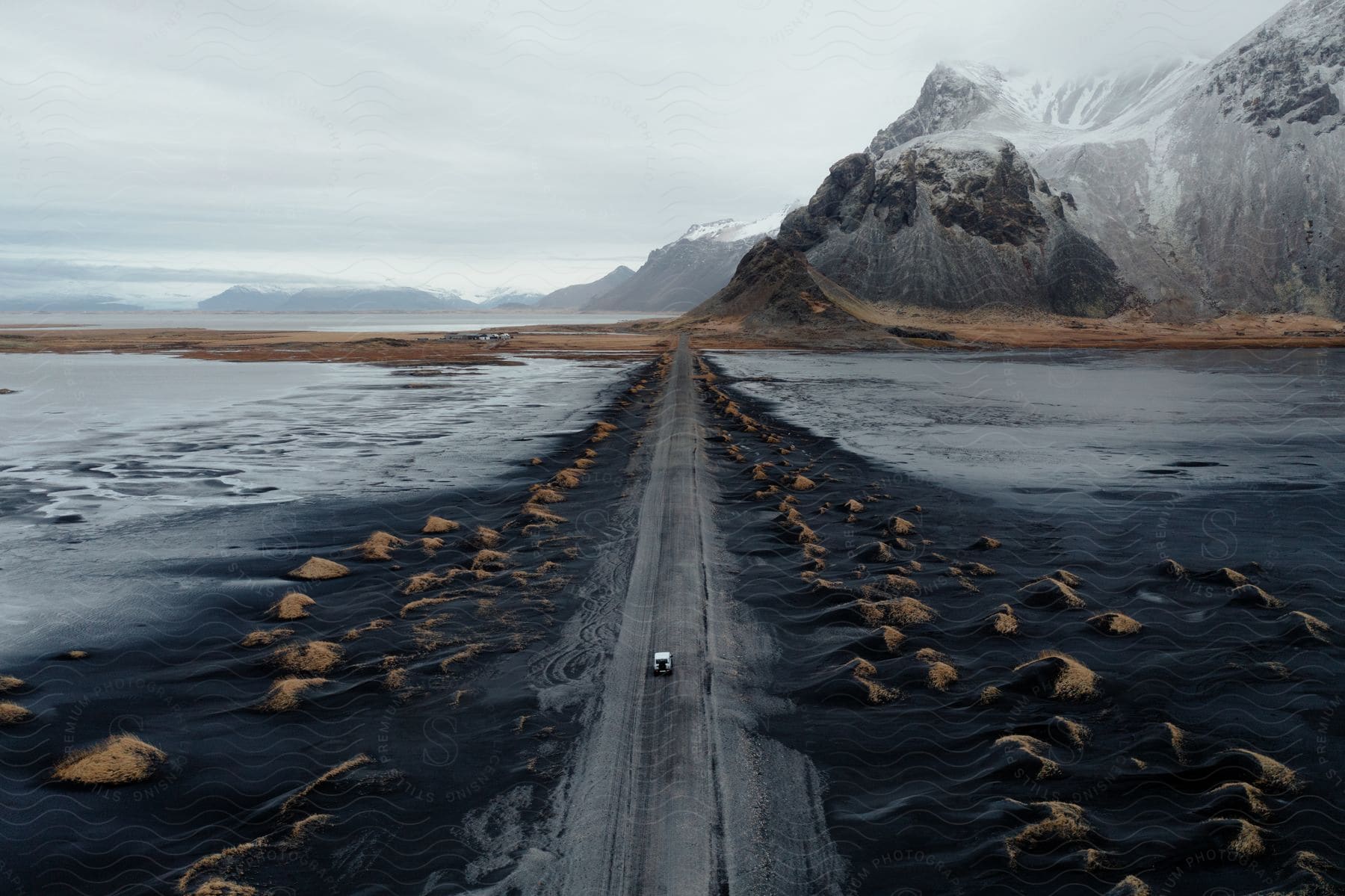 A serene winter landscape with a frozen lake surrounded by mountains and trees