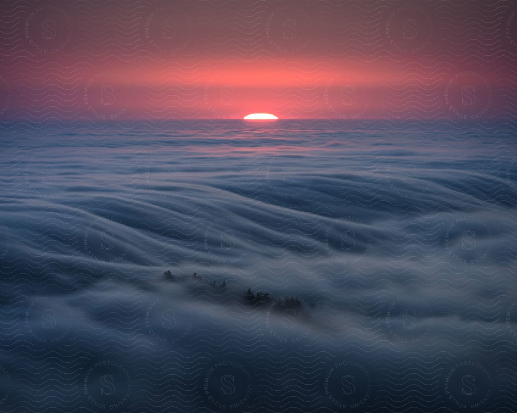 Clouds rolling over a mountain during sunset