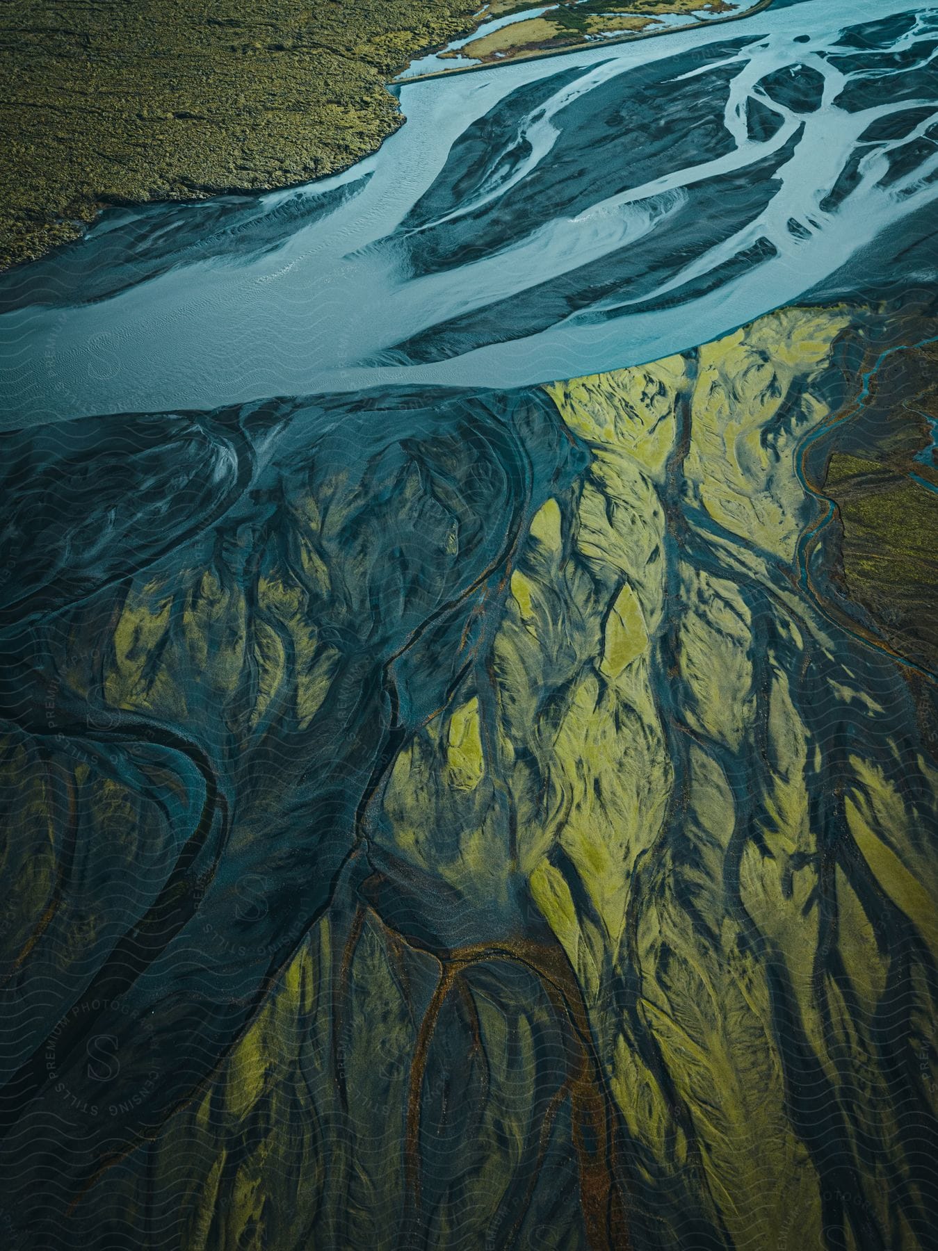 A river runs through a muddy delta in an aerial view of icelands landscape