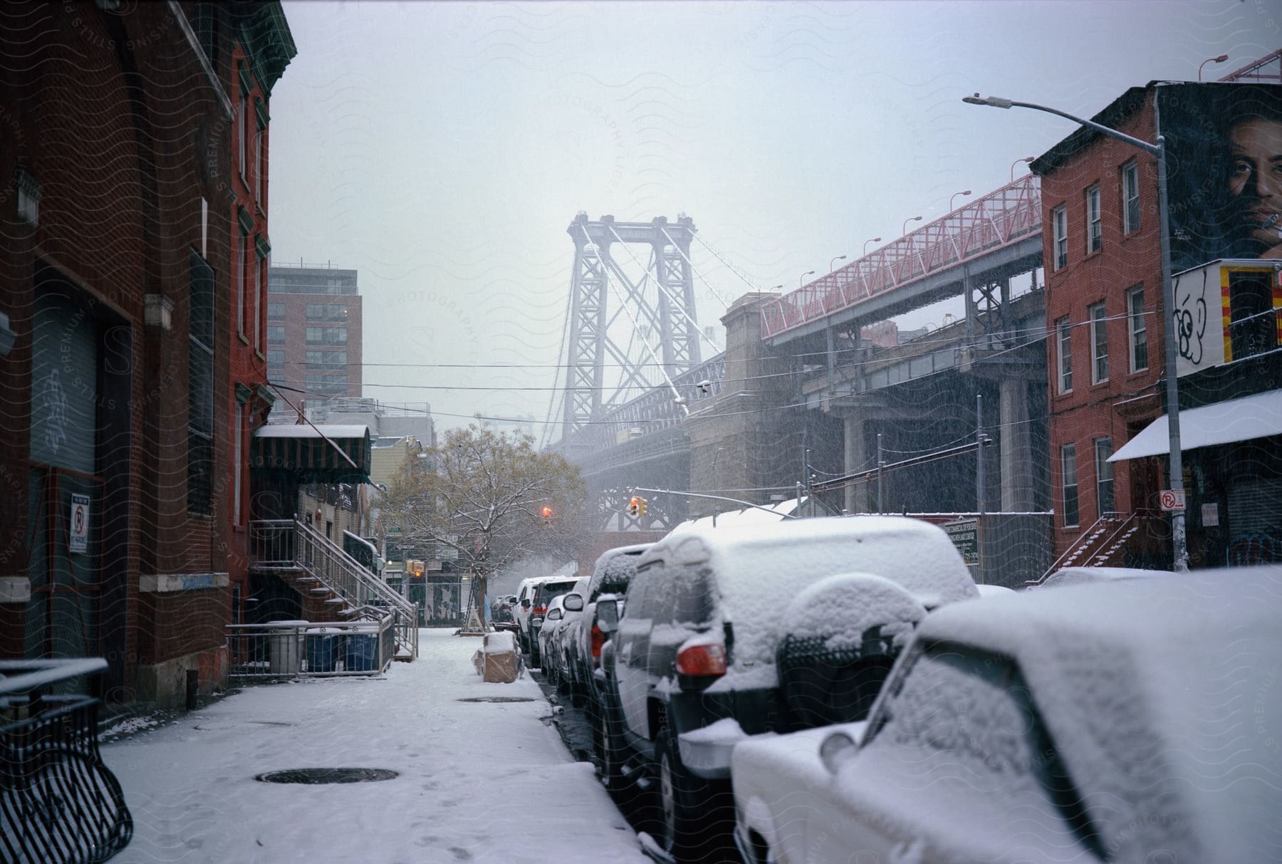 A snowy city street with a car parked on the side