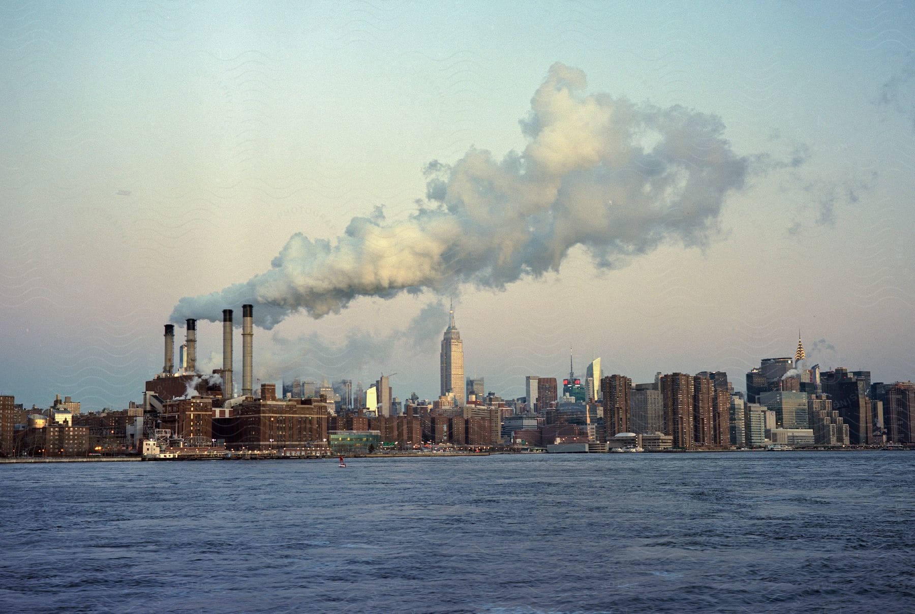 A city skyline with skyscrapers and smoke