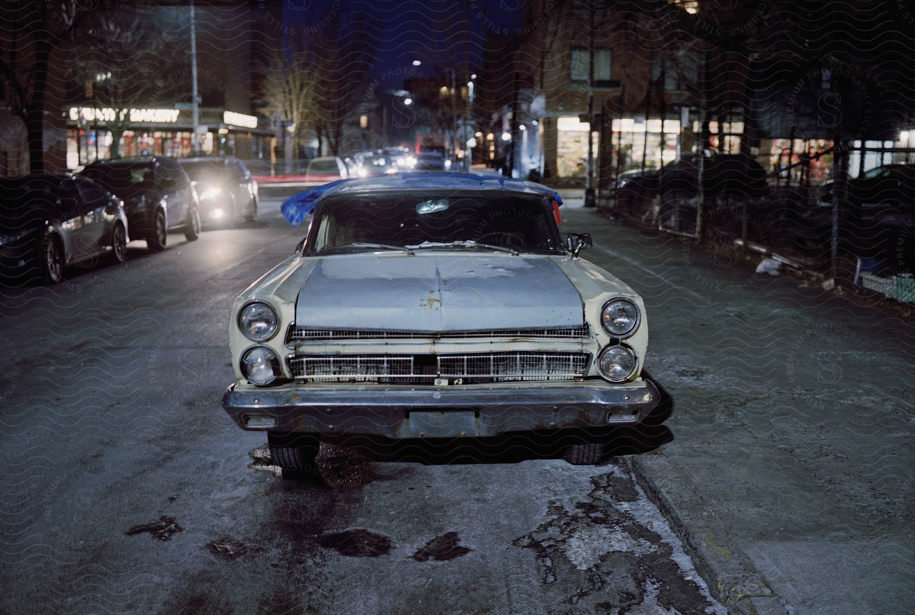 An old car parked on a downtown street with nobody inside